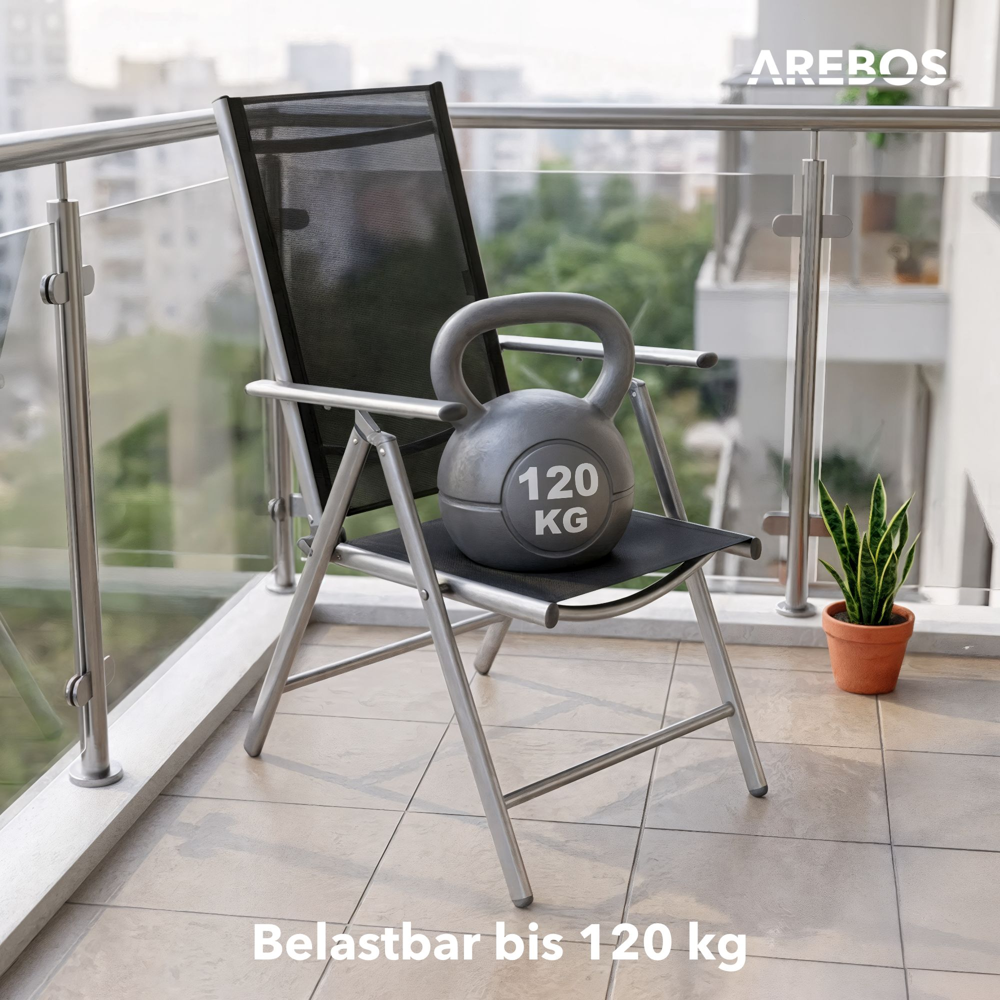 Graue Kettlebell mit 120 kg auf einem silbernen Klappstuhl auf einem Balkon.
