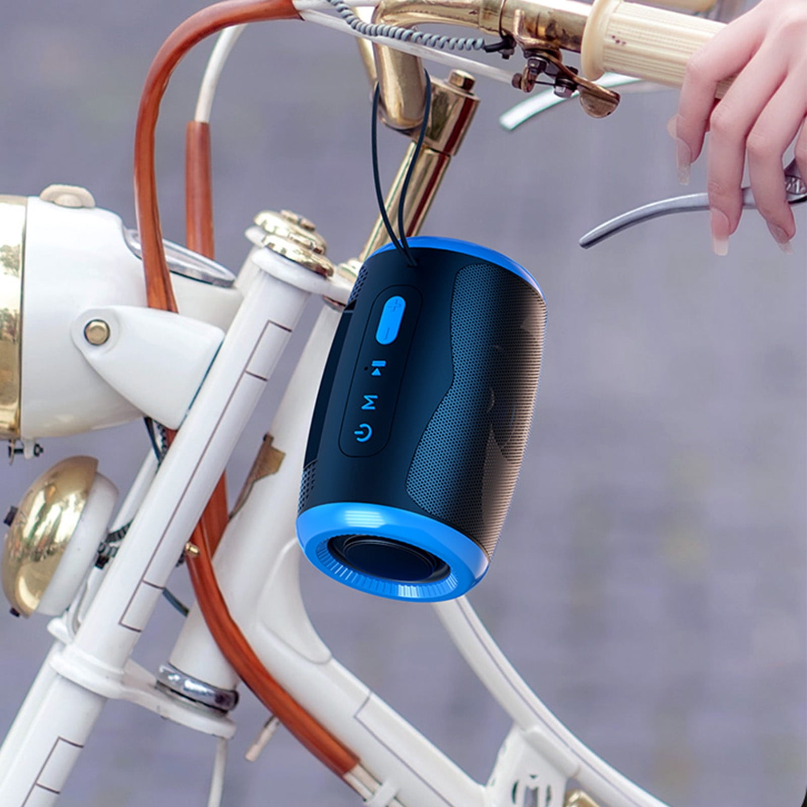 Ein tragbarer blauer und schwarzer Lautsprecher hängt an einem Fahrradlenker.
