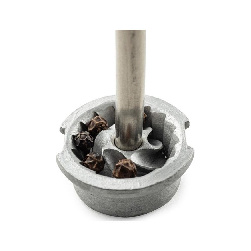 Nahaufnahme eines Mörsers mit Pfefferkörnern und einem Metallgriff.