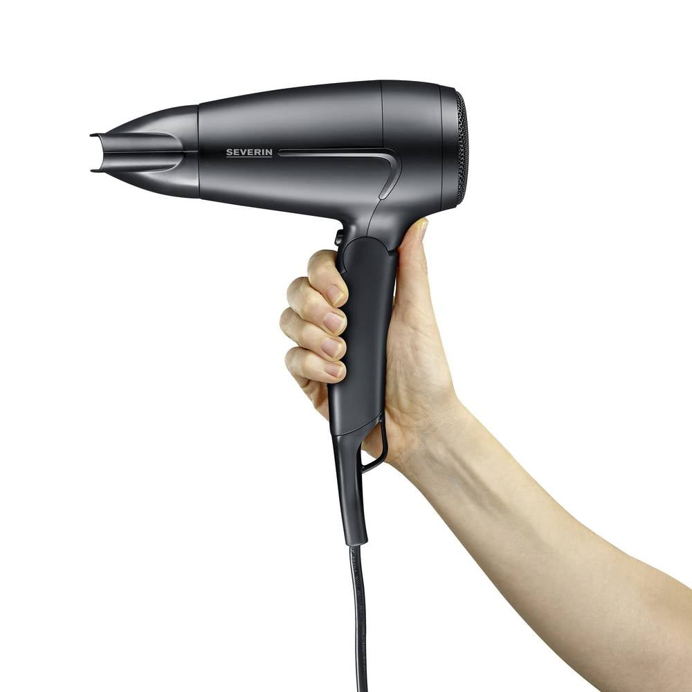 Dłoń trzyma ciemną suszarkę do włosów z kablem na białym tle.