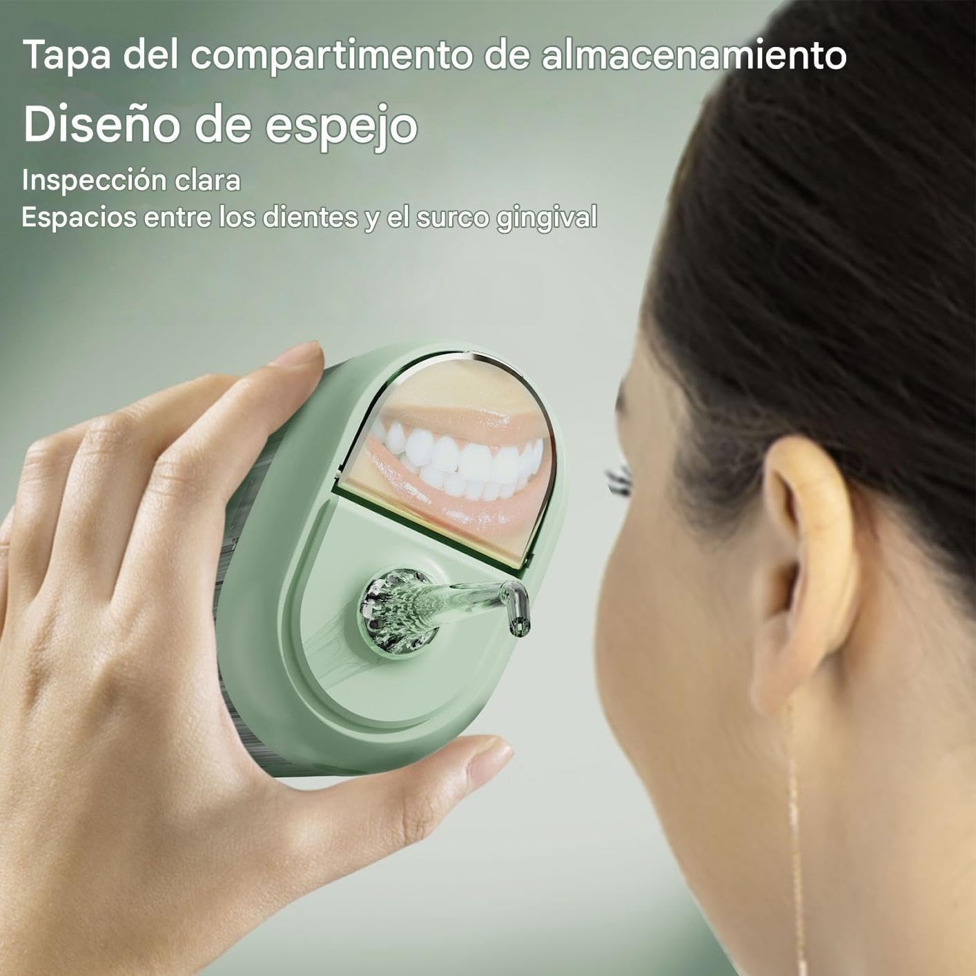 Una mano sujeta un dispositivo verde con un espejo que refleja dientes.