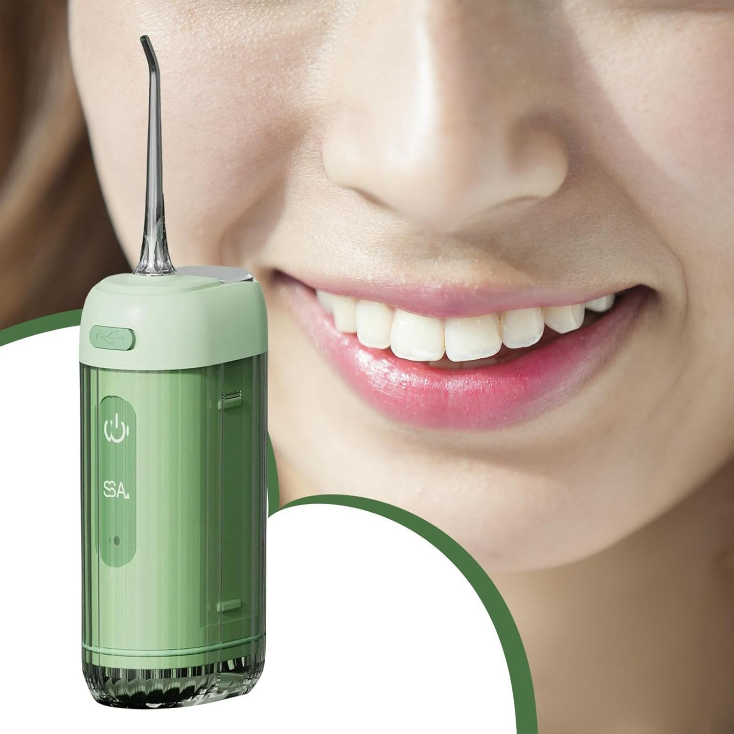 Irrigador bucal verde y parte de una sonrisa. Chorro de agua visible.