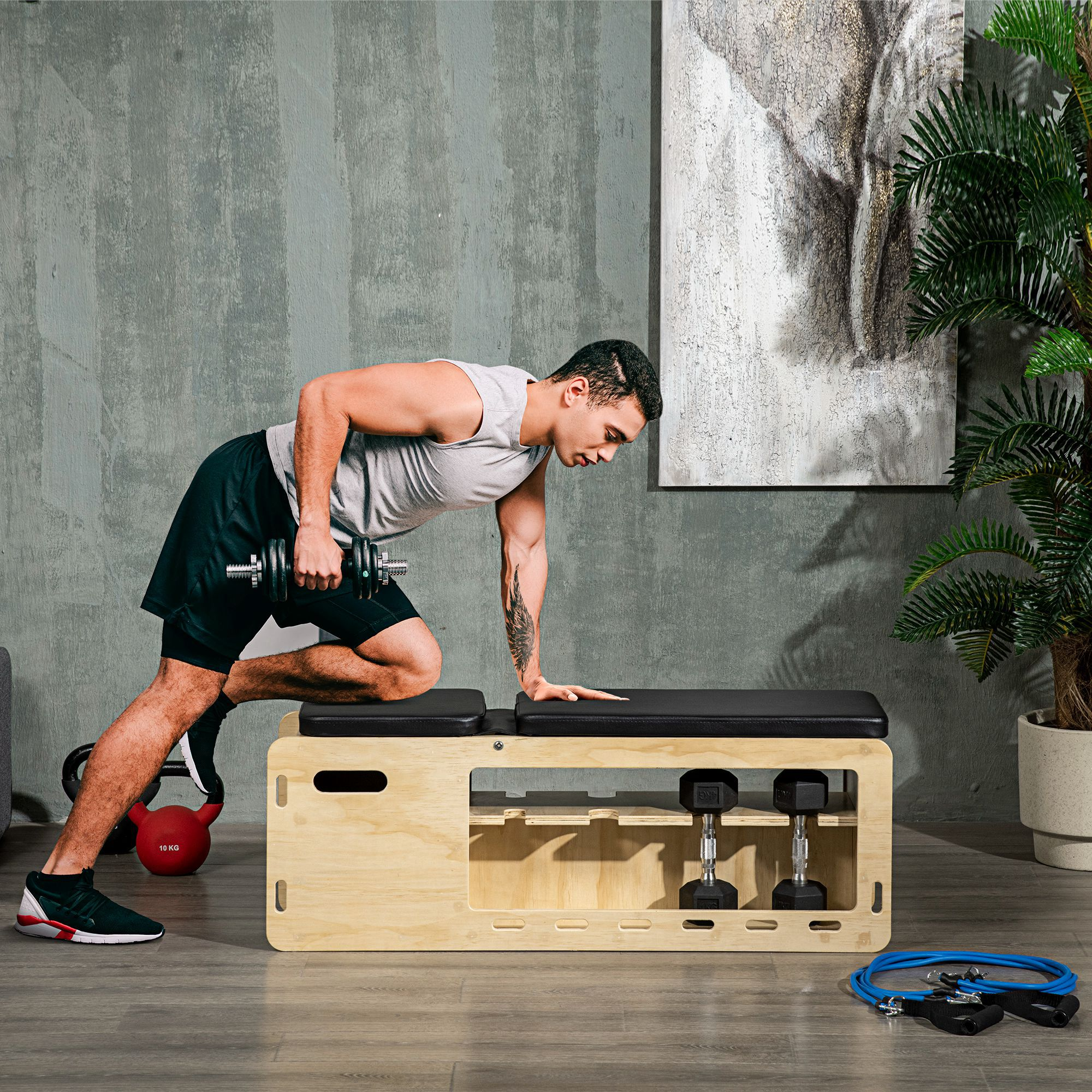 Mann trainiert mit Hantel auf Trainingsbank. Hanteln, Kettlebell, Seil.