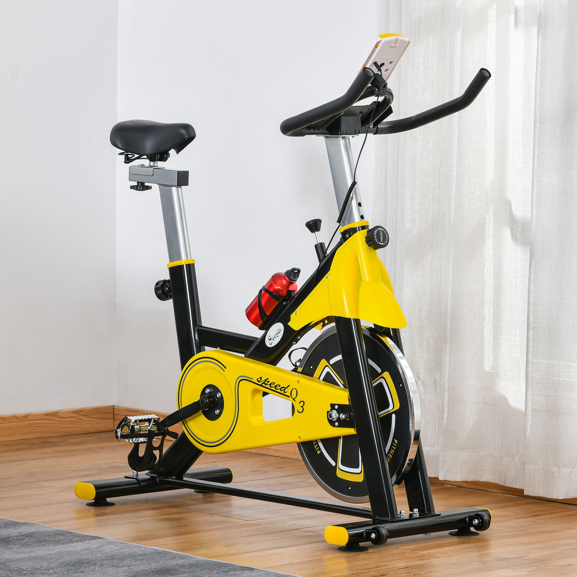 Ein gelbes und schwarzes Heimtrainerfahrrad mit Flaschenhalter steht auf einem Holzboden.