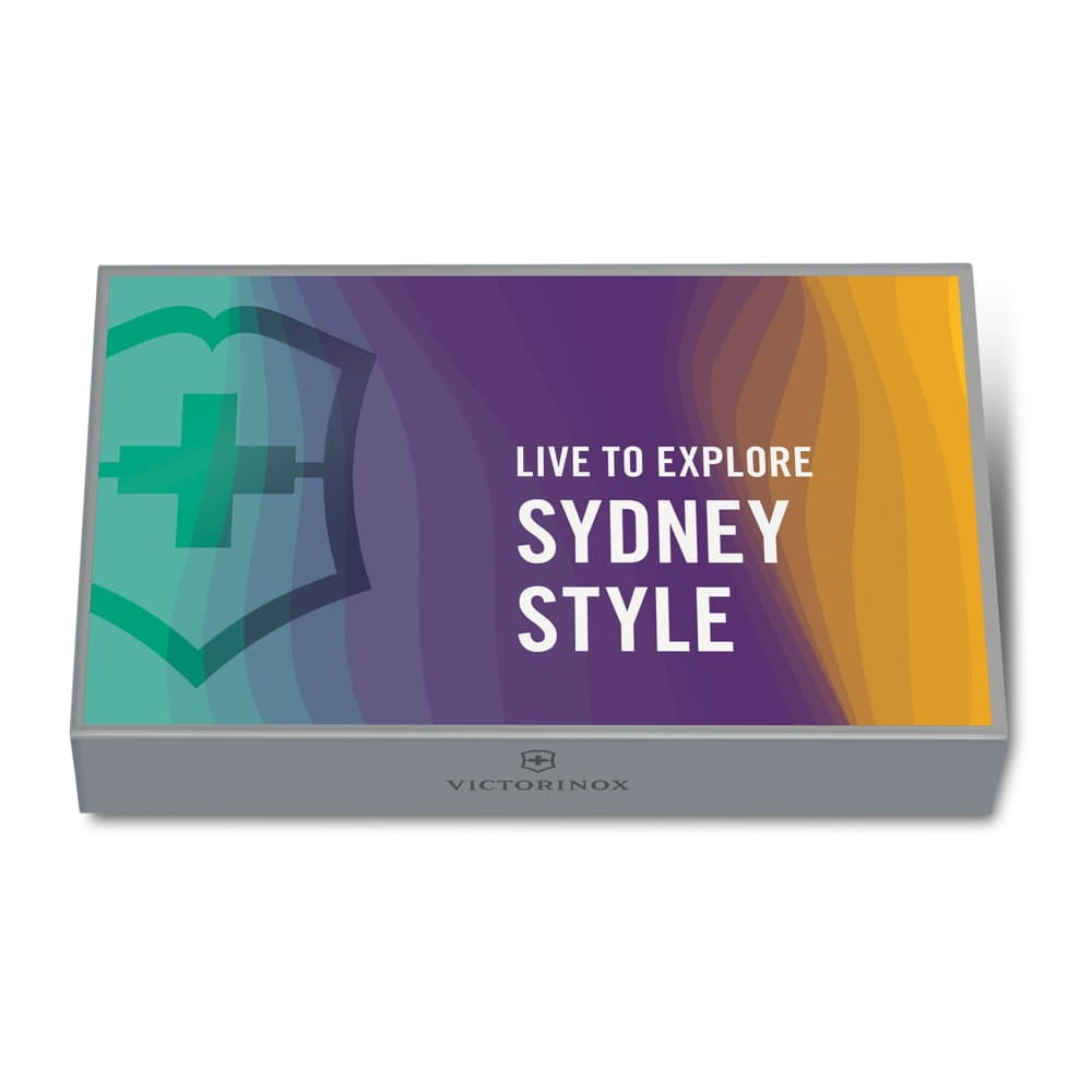 Victorinox logolu gri kutu. Ön yüzünde haçlı kalkan, üzerinde yazı: Live to Explore Sydney Style.