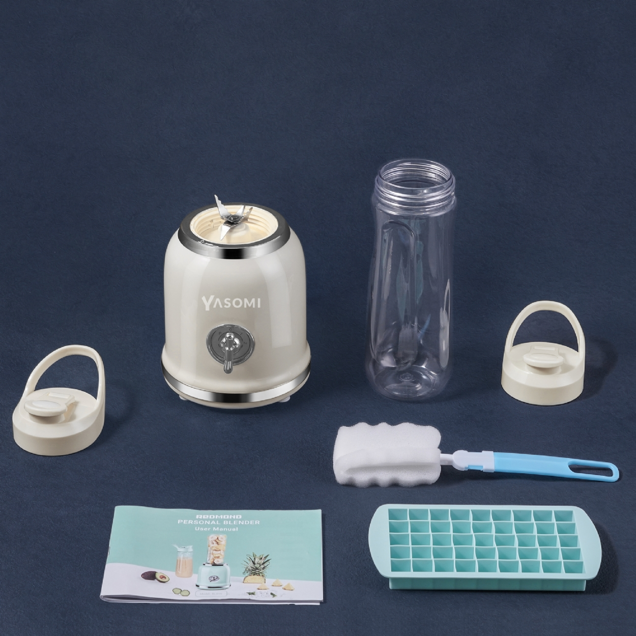 Krem rengi blender, şişe, kapak, kullanım kılavuzu, buz kalıbı ve fırça mavi arka planda.