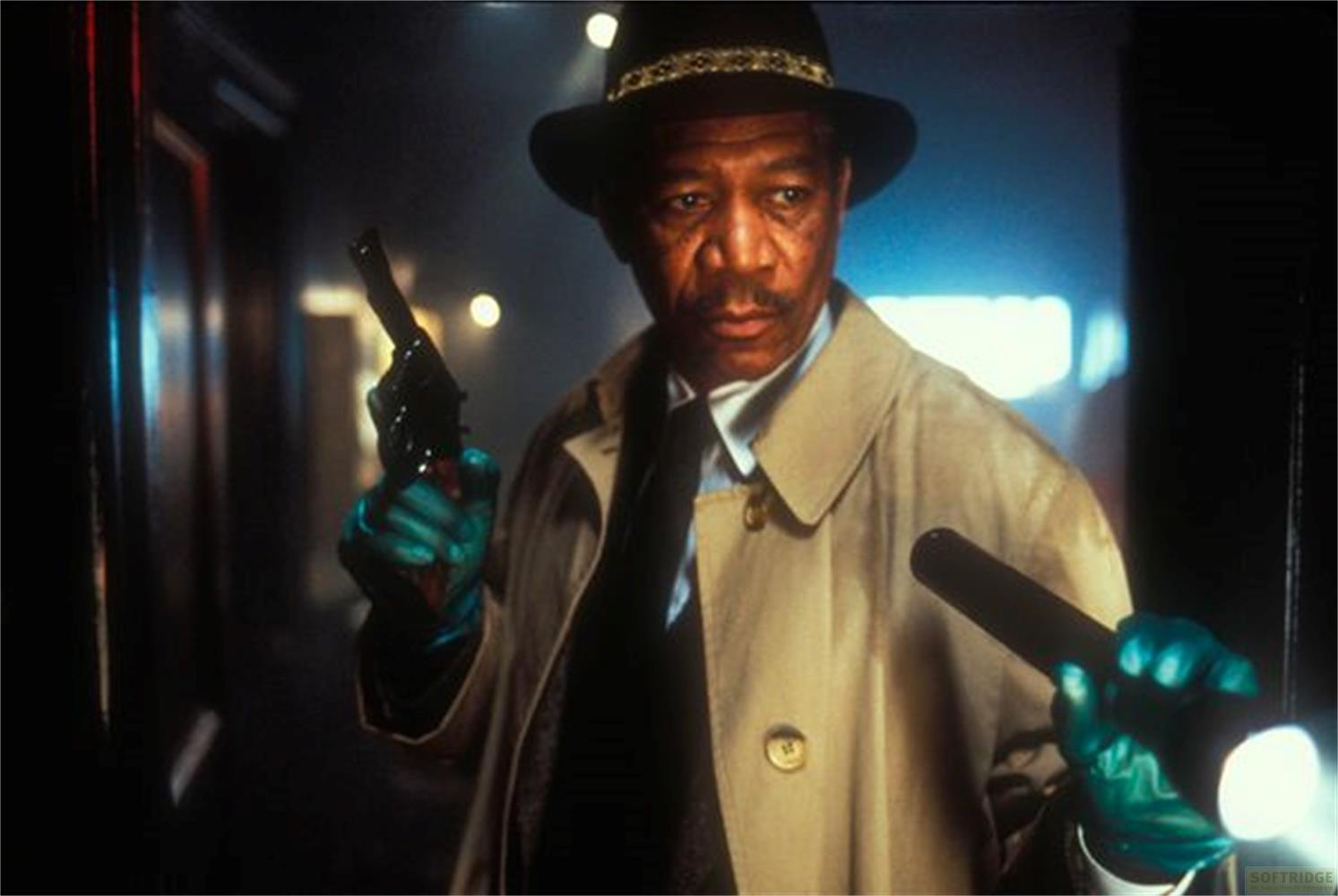Ein Mann in einem Hut und Trenchcoat hält eine Pistole und eine Taschenlampe.