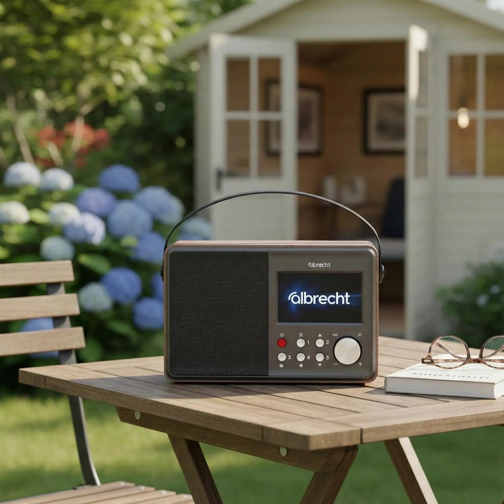 Una radio Albrecht su un tavolo da giardino. Un capanno sullo sfondo.