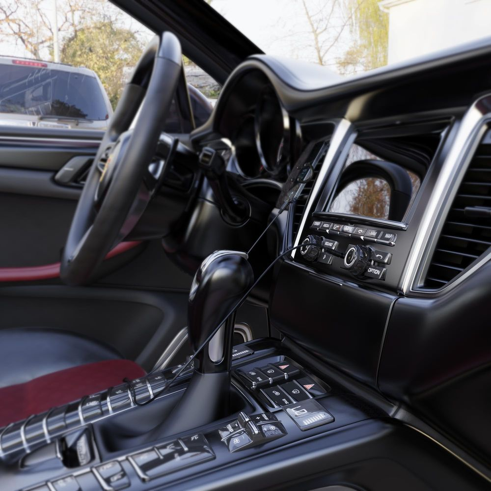Innenraum eines Autos mit Lenkrad, Gangschaltung und Touchscreen.