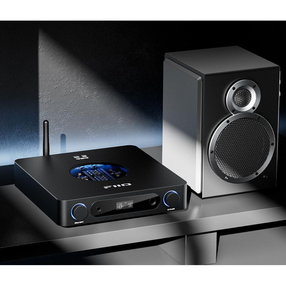 Czarny odtwarzacz audio obok czarnego głośnika na p ółce.