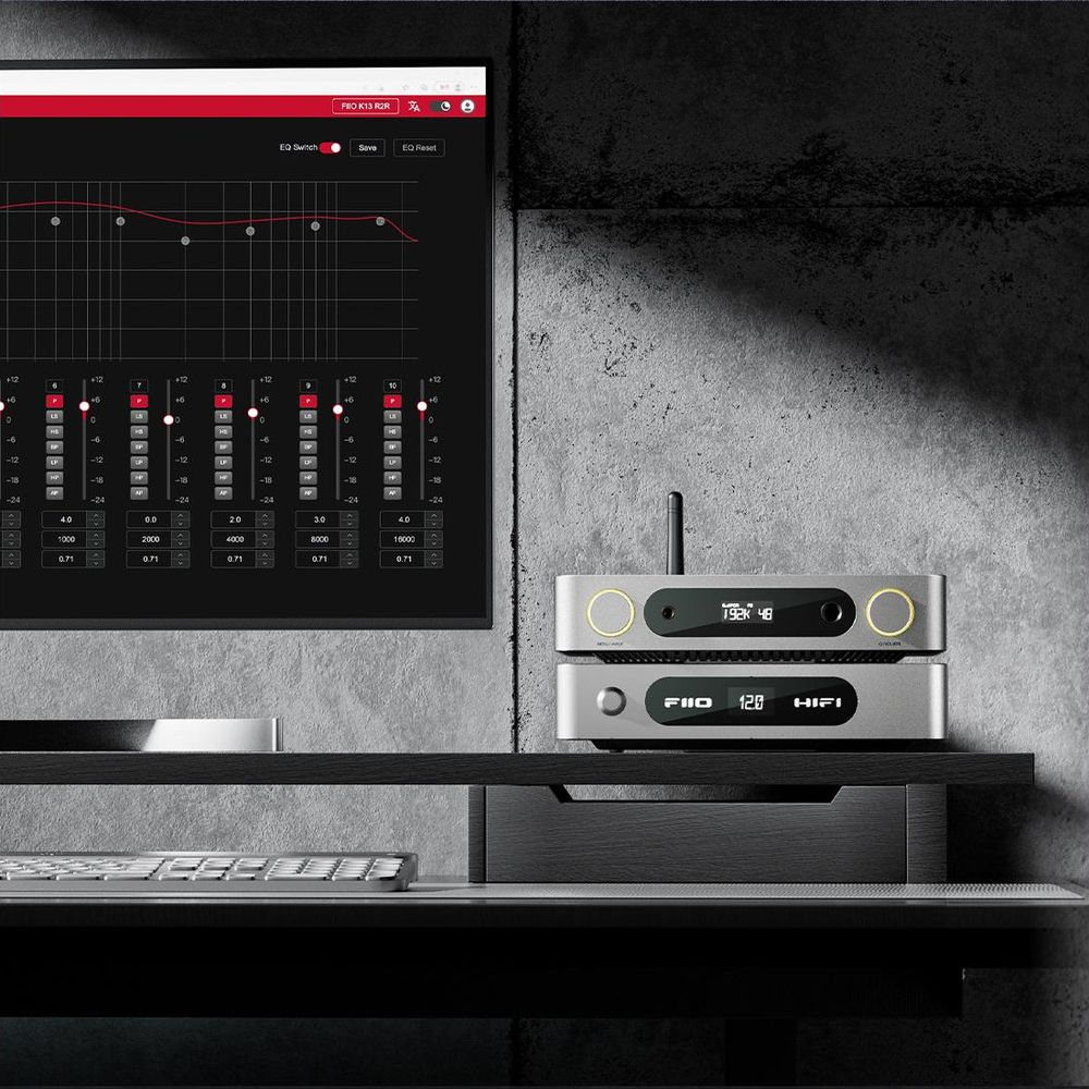 Monitor wyświetla wykres korektora. Poniżej ułożone są dwa srebrne urządzenia audio FiiO.