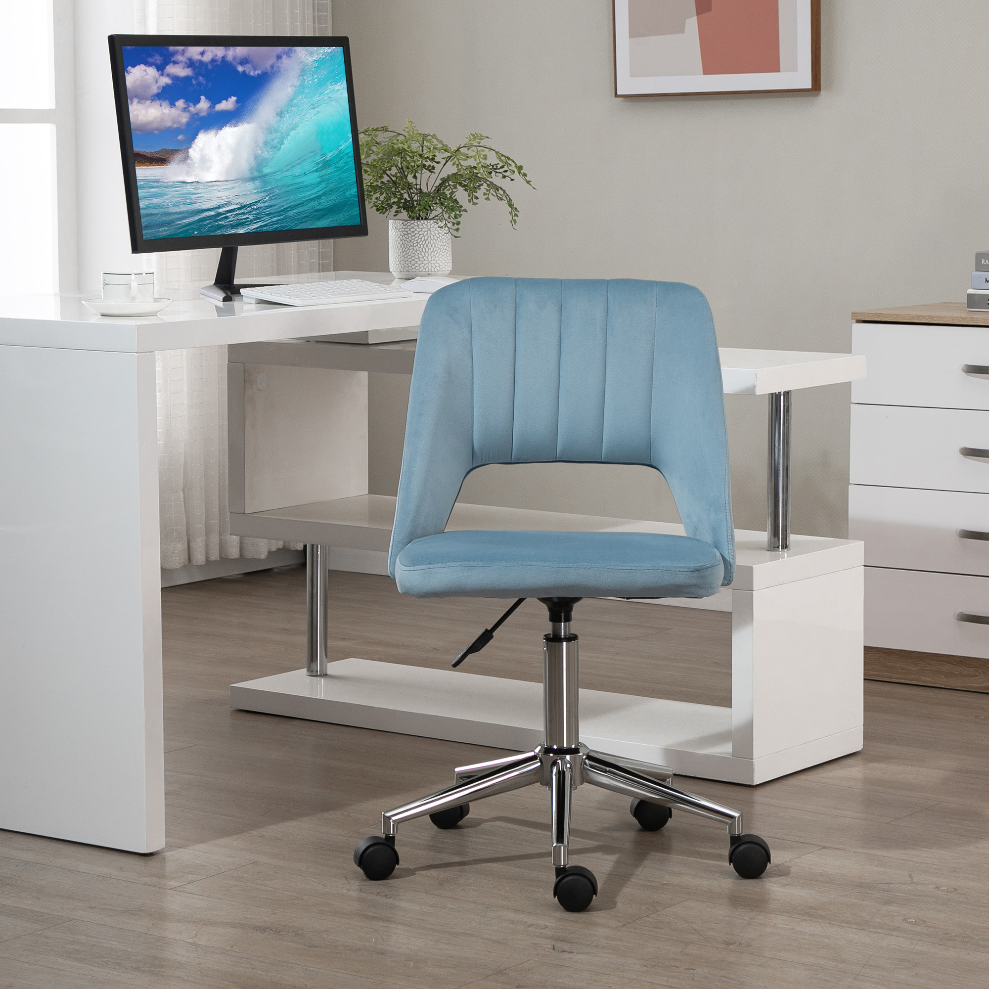 Ein blauer Bürostuhl steht vor einem weißen Schreibtisch mit einem Computermonitor.