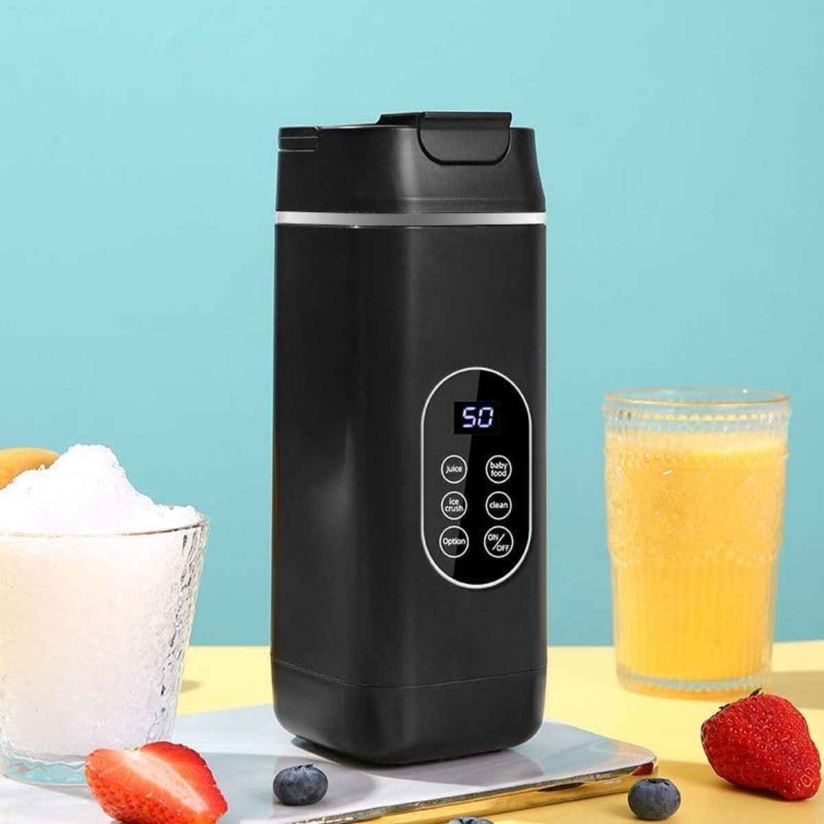 Schwarzer Mixer mit Glas Eis, Orangensaft, Erdbeeren und Blaubeeren.