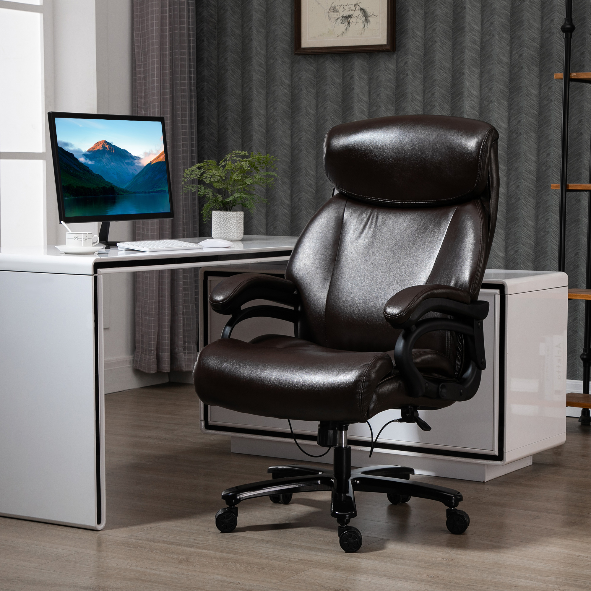 Ein brauner Ledersessel vor einem weißen Schreibtisch mit einem Computermonitor.