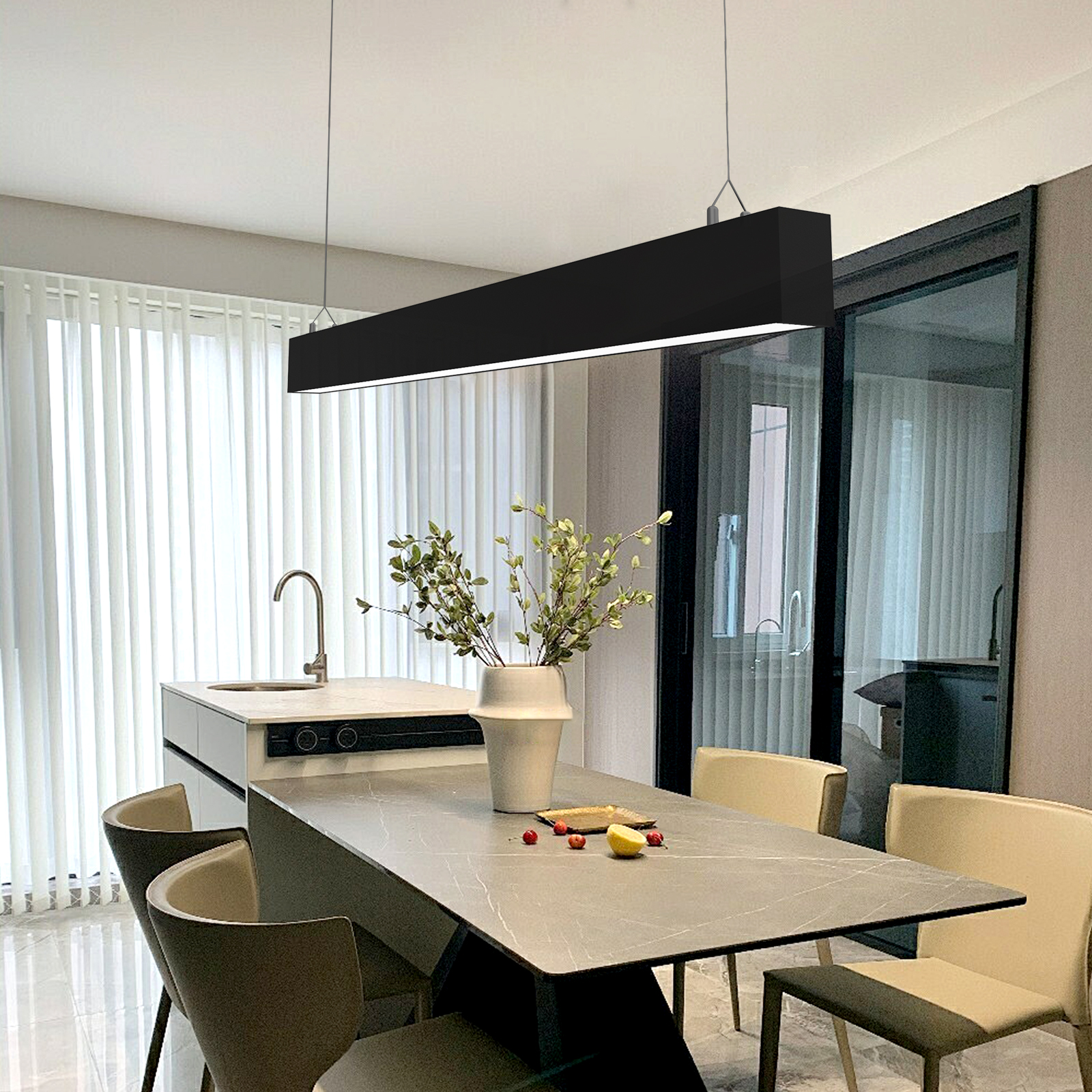 Un comedor moderno con isla de cocina, sillas y lámpara colgante.