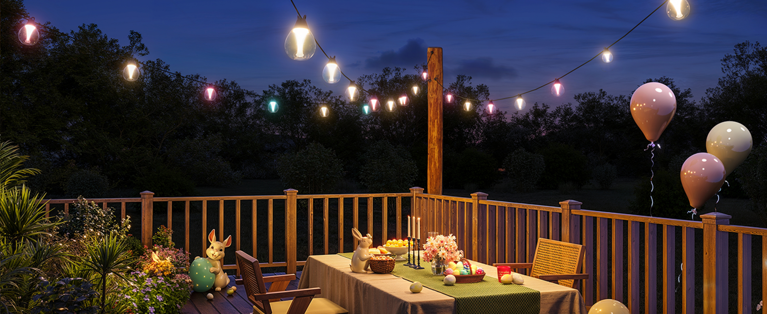 Osterparty auf einer Terrasse bei Nacht mit Lichterketten und Ballons.