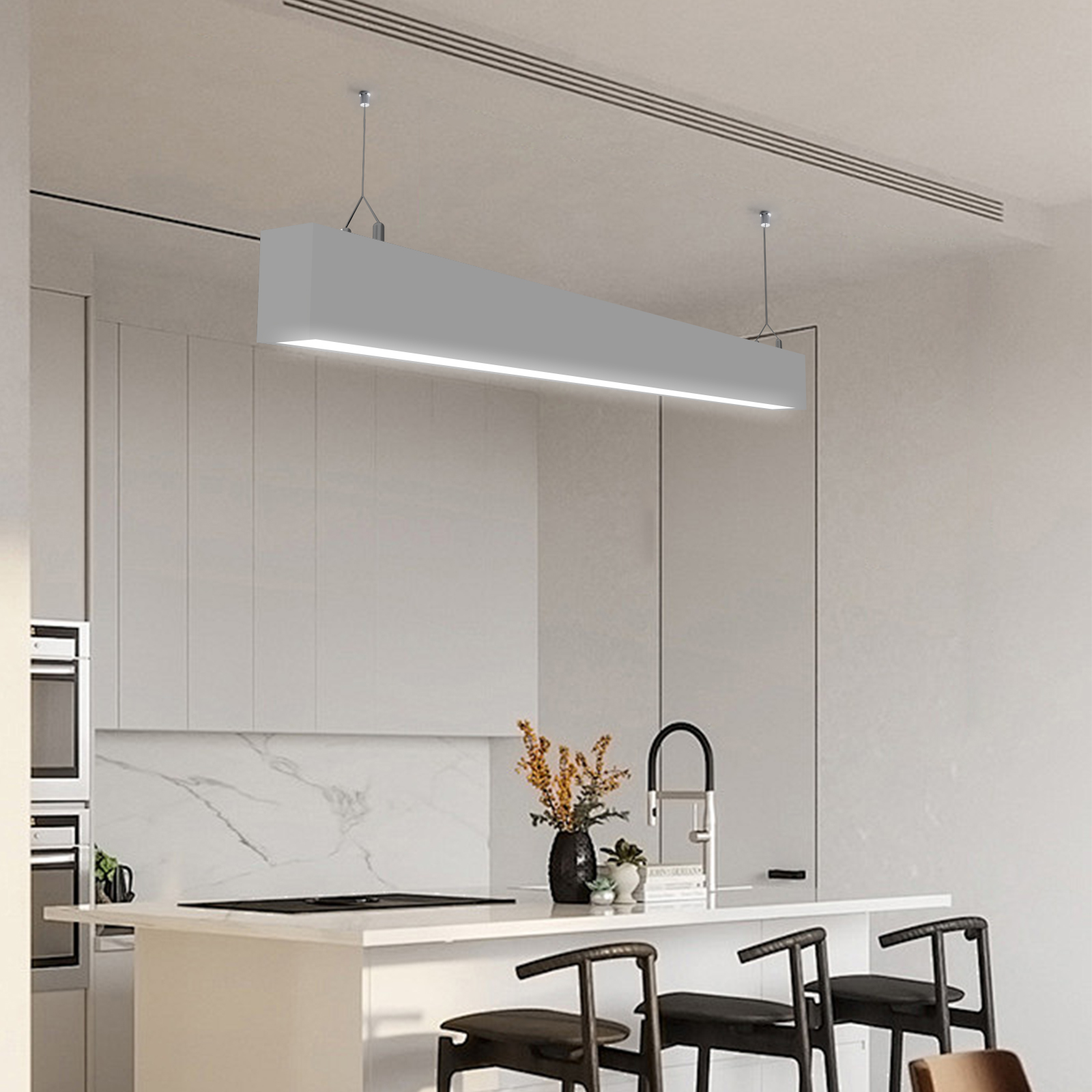 Una cocina moderna con una lámpara colgante gris larga sobre una isla.