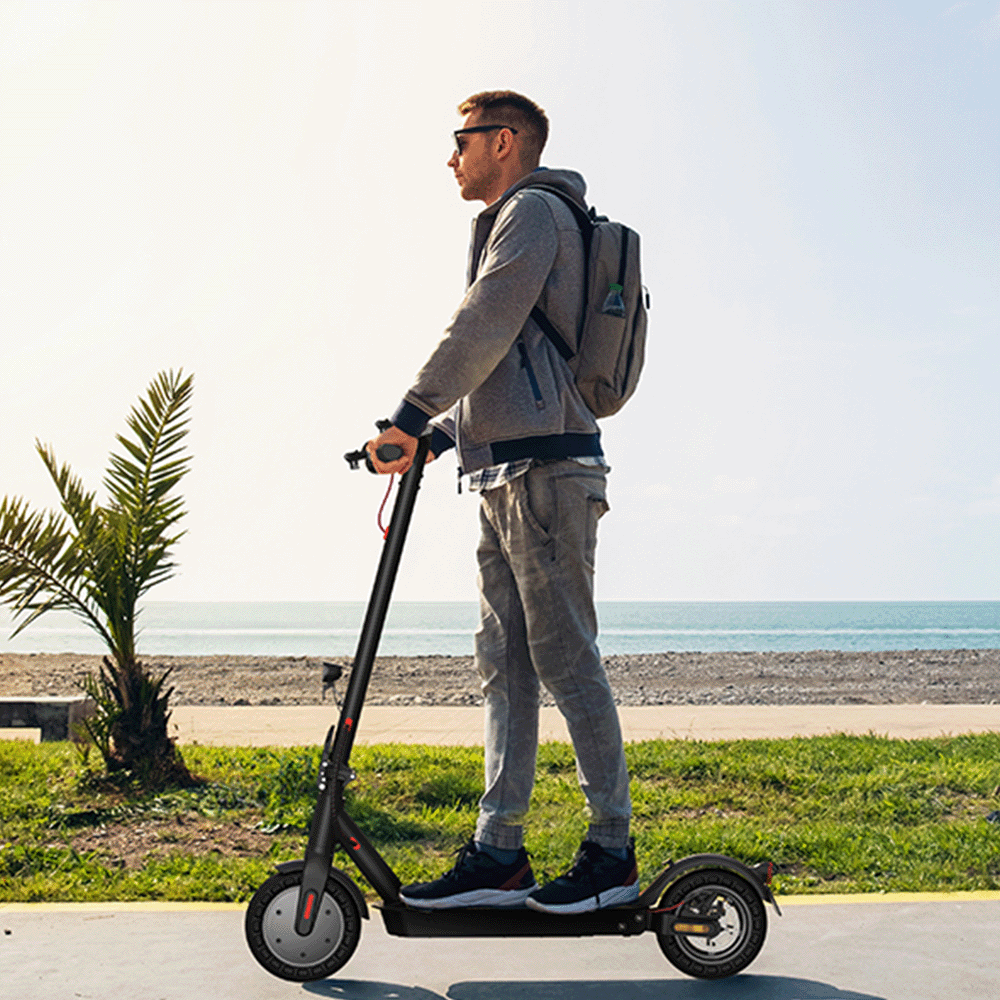 Mann auf E-Scooter am Meer