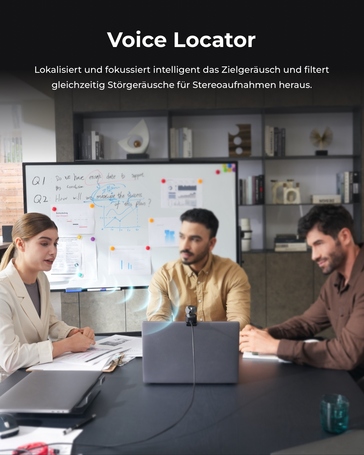 Menschen in einem Meeting um einen Laptop mit einem Mikrofon.