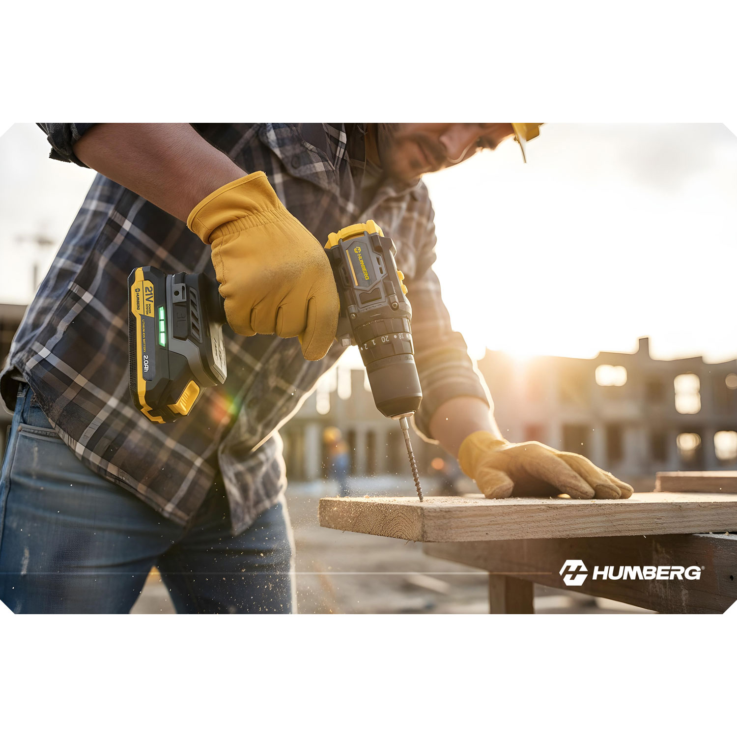 Mężczyzna w żółtych rękawicach wierci w drewnie wkrętarką. W tle plac budowy.