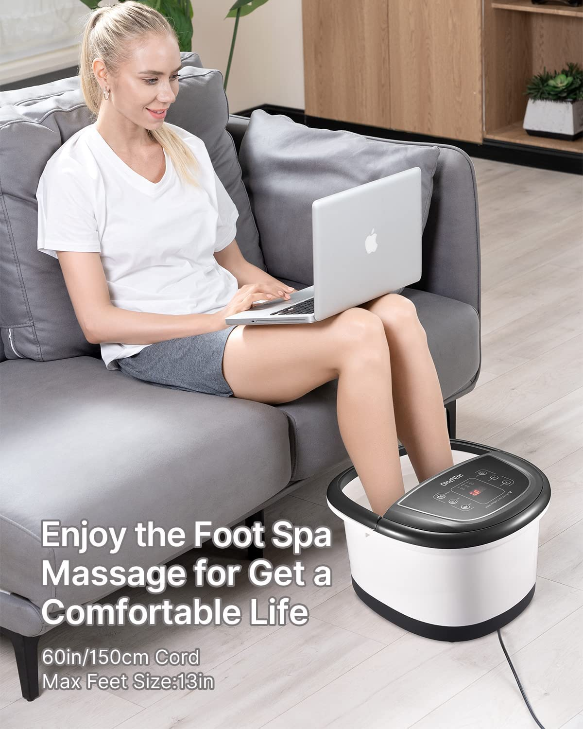 Eine Frau sitzt auf einem Sofa und benutzt einen Laptop, während ihre Füße in einer Fußmassagevorrichtung sind.