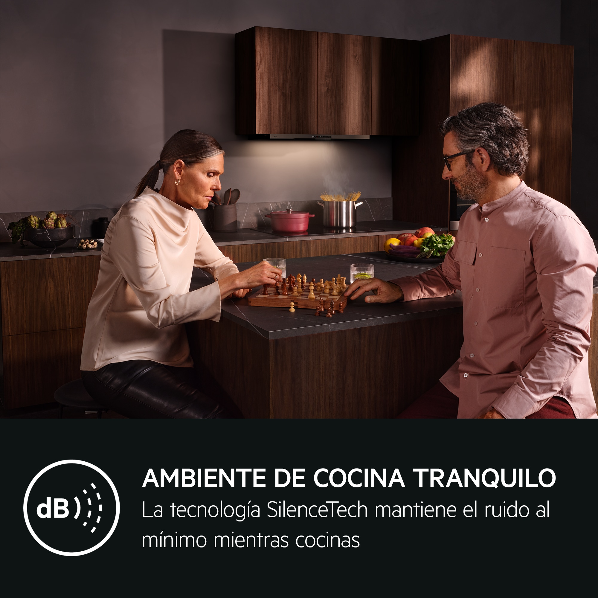 Una coppia gioca a scacchi in una cucina moderna mentre la pasta cuoce.
