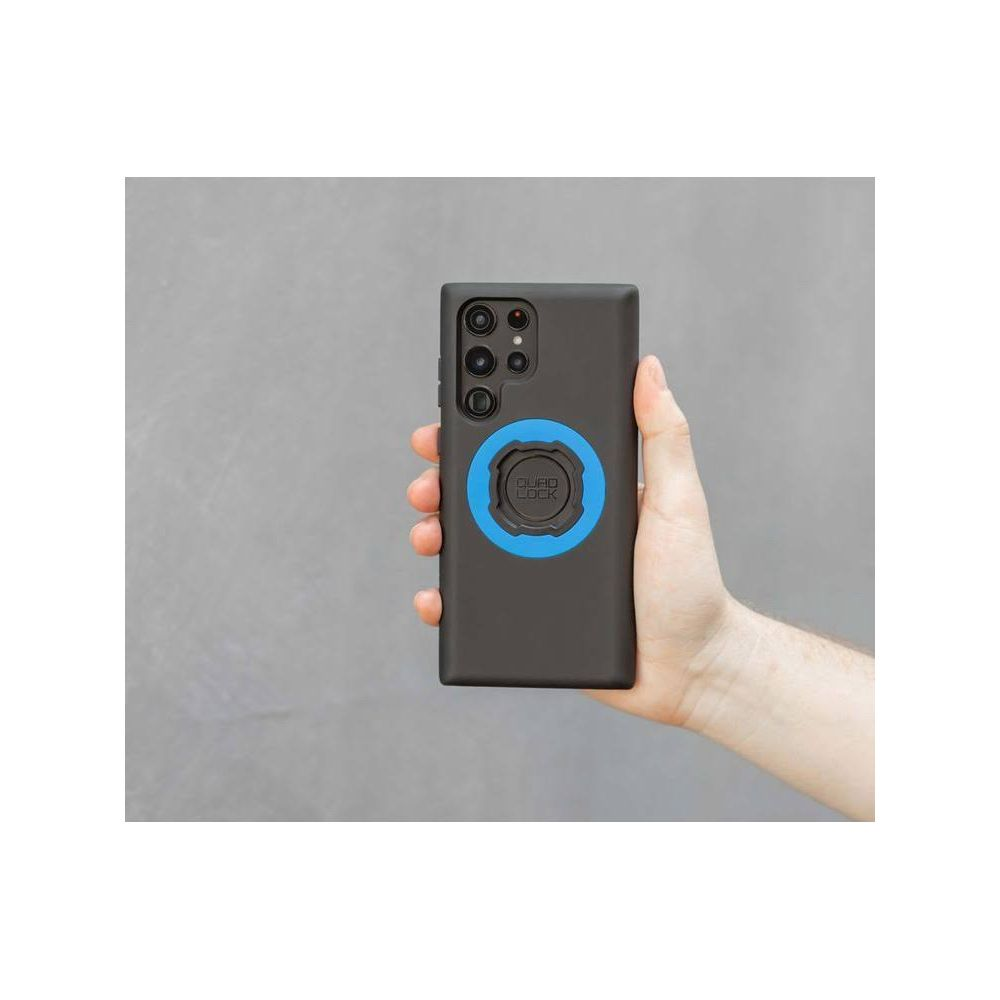 Eine Hand hält ein schwarzes Handy mit blauem Ringhalter.
