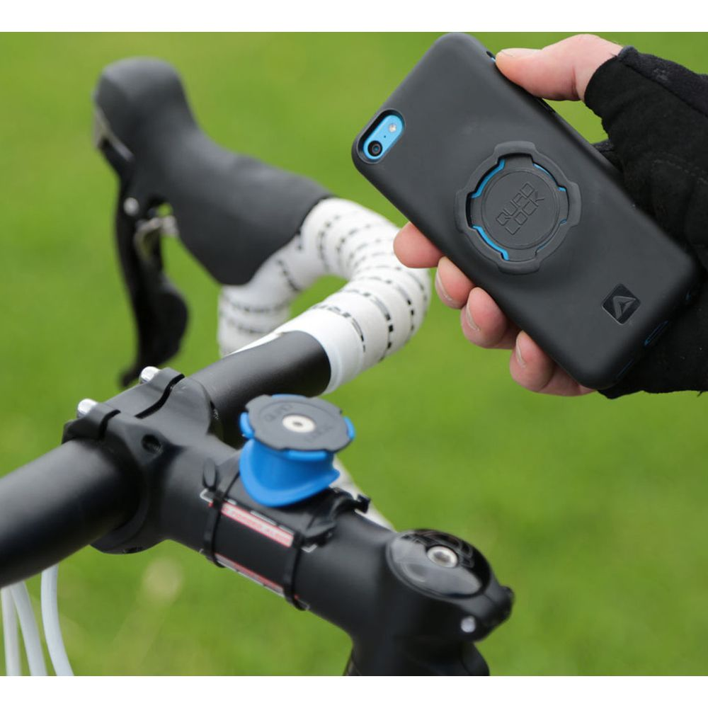 Hand hält schwarzes Handyhülle mit blauer Quad Lock Halterung nahe Fahrradlenker.