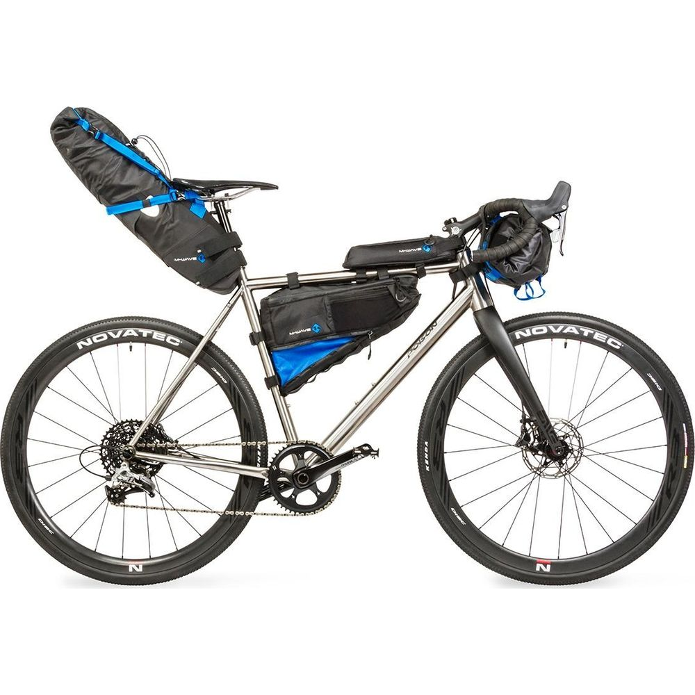 Una bicicleta plateada con alforjas y bolsas de cuadro, fondo blanco.