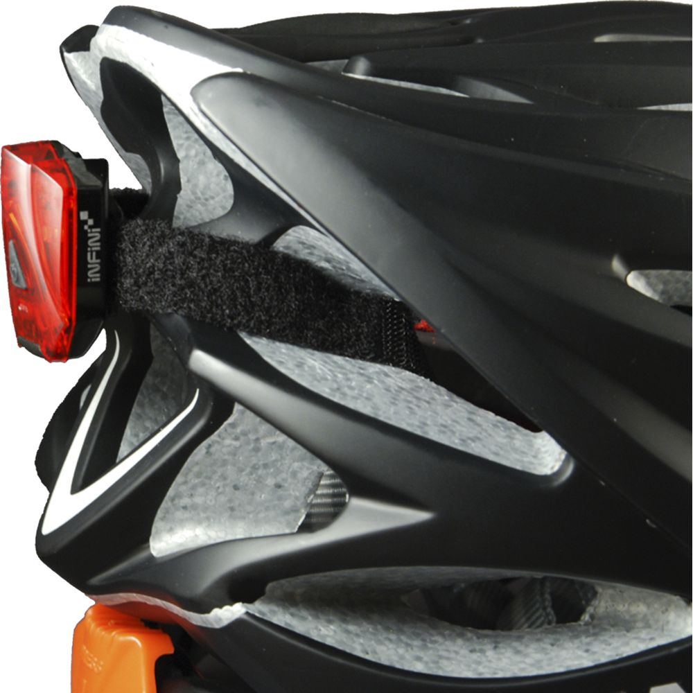 Nahaufnahme eines schwarzen Fahrradhelms mit rotem Rücklicht und orangefarbenen Halterungen.