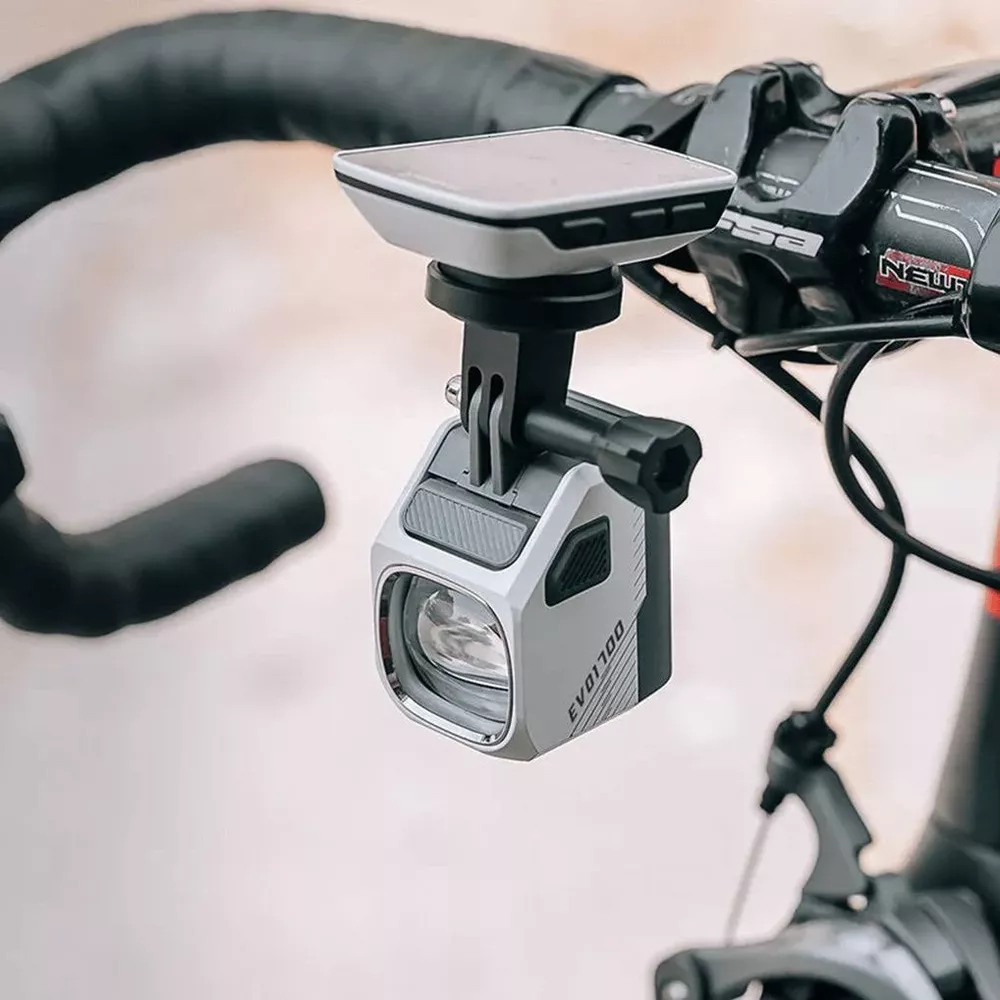 Ein silberner Fahrradscheinwerfer mit einem Computerhalter darüber, montiert am Lenker.
