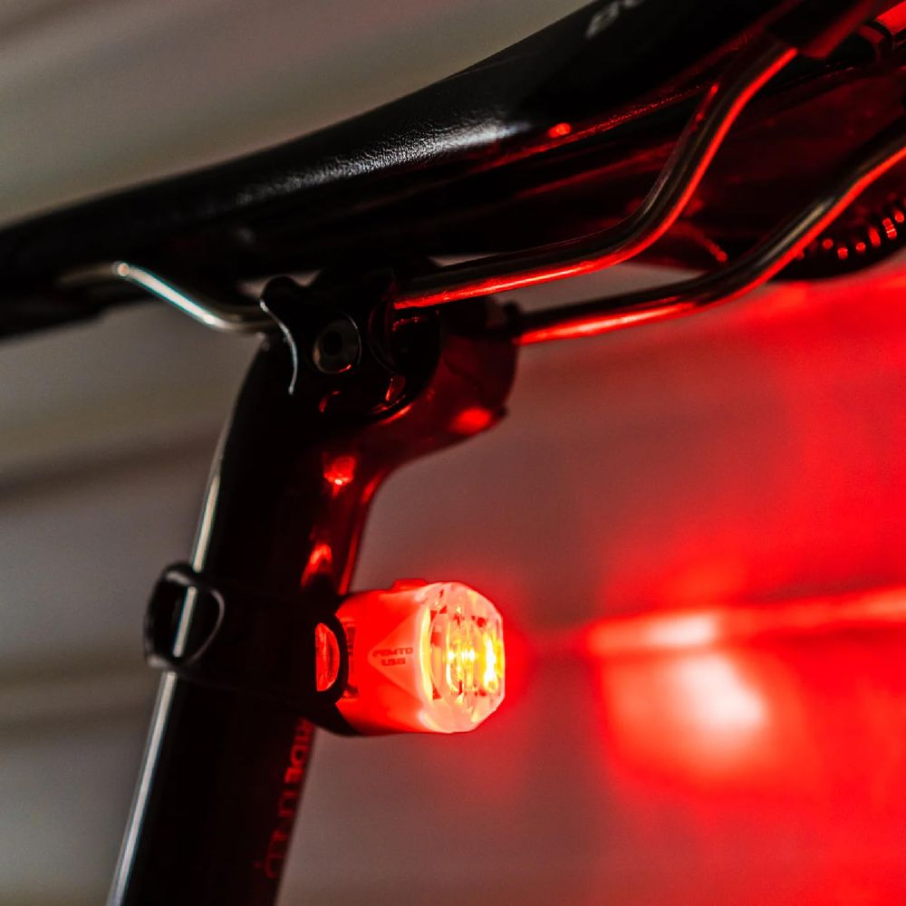 Una luce posteriore rossa per bicicletta brilla sul reggisella.