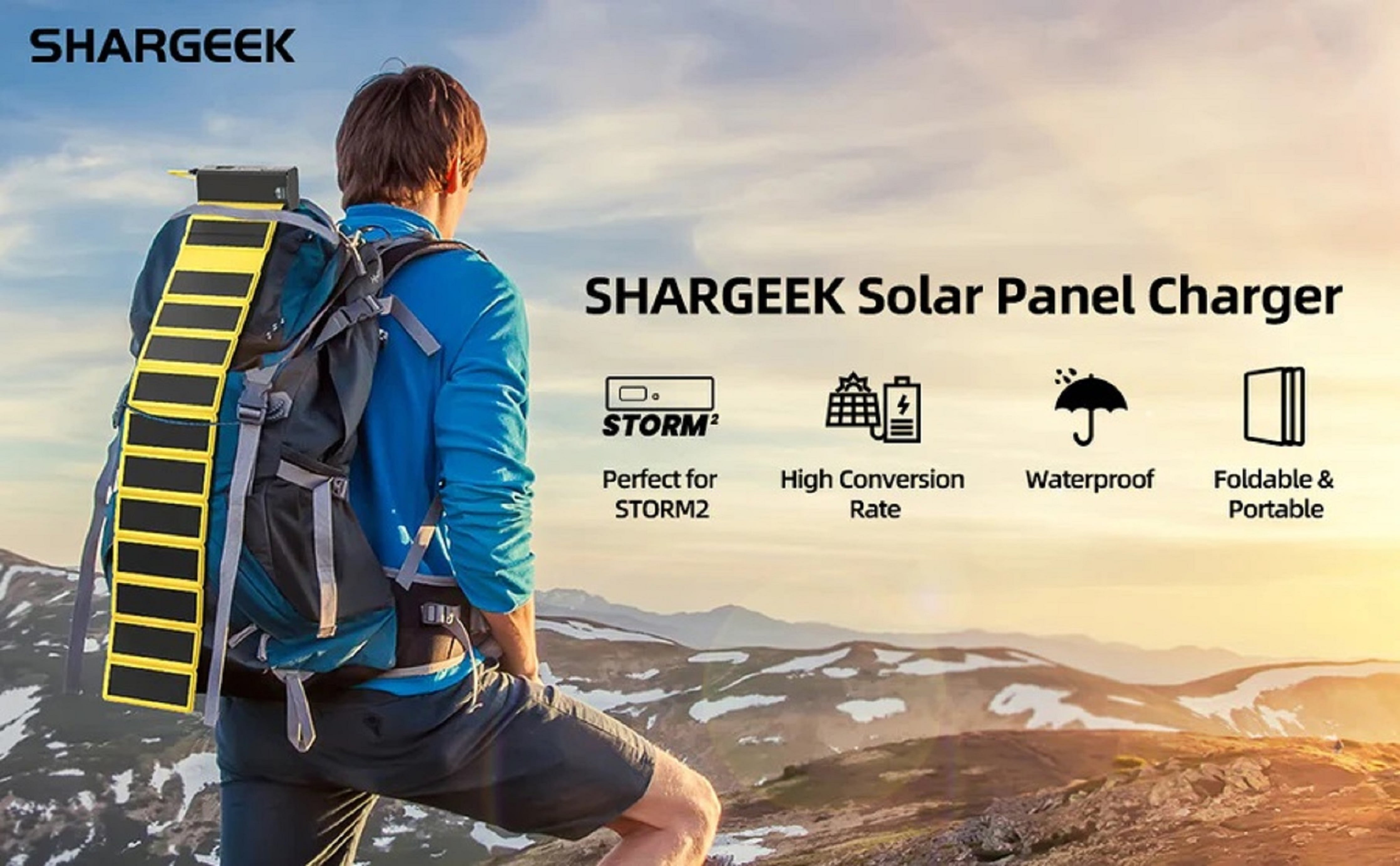 Mann mit Rucksack und Solarpanel-Ladegerät in bergiger Landschaft.