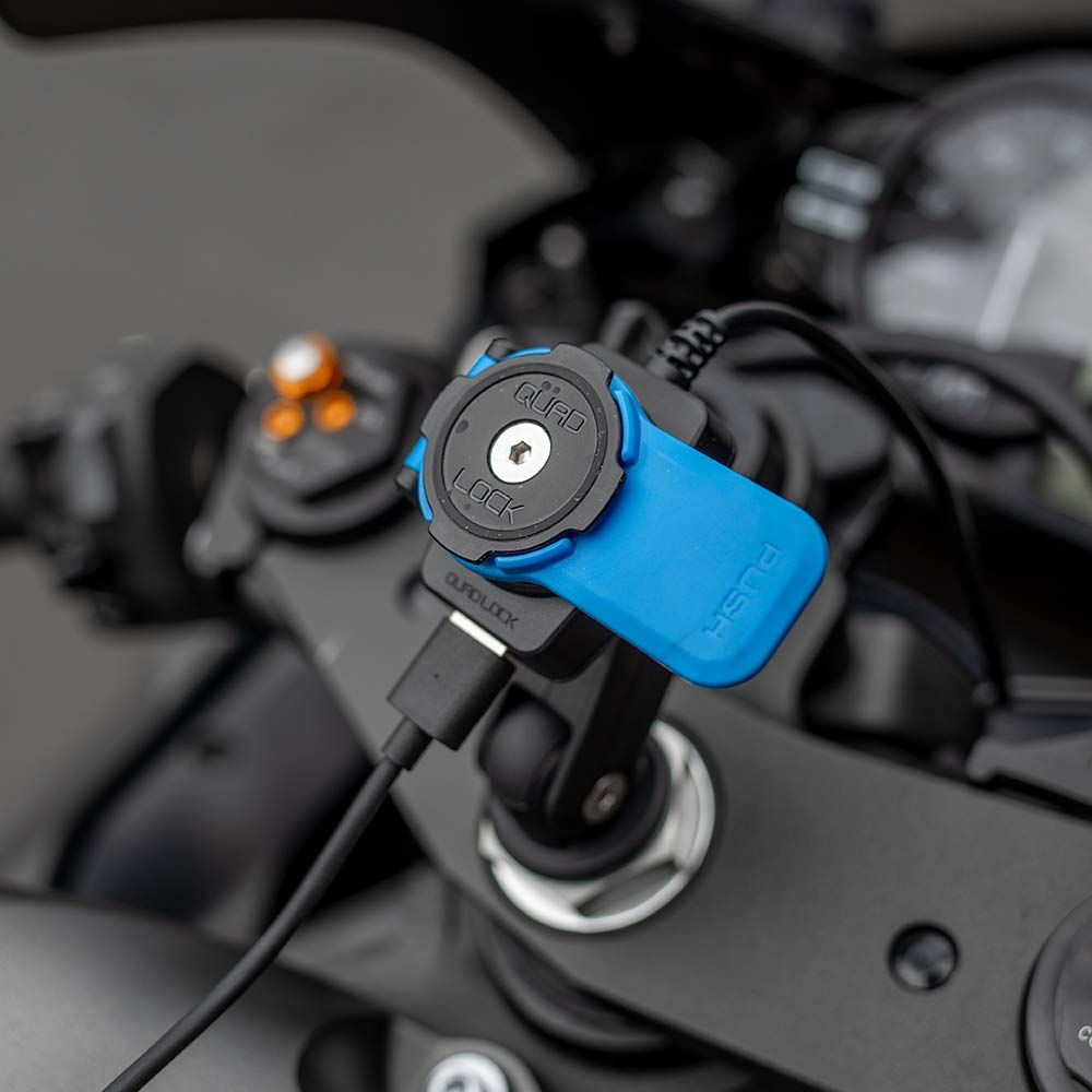 Ein blauer Quad Lock Halter mit USB-Kabel an einem Motorradlenker.