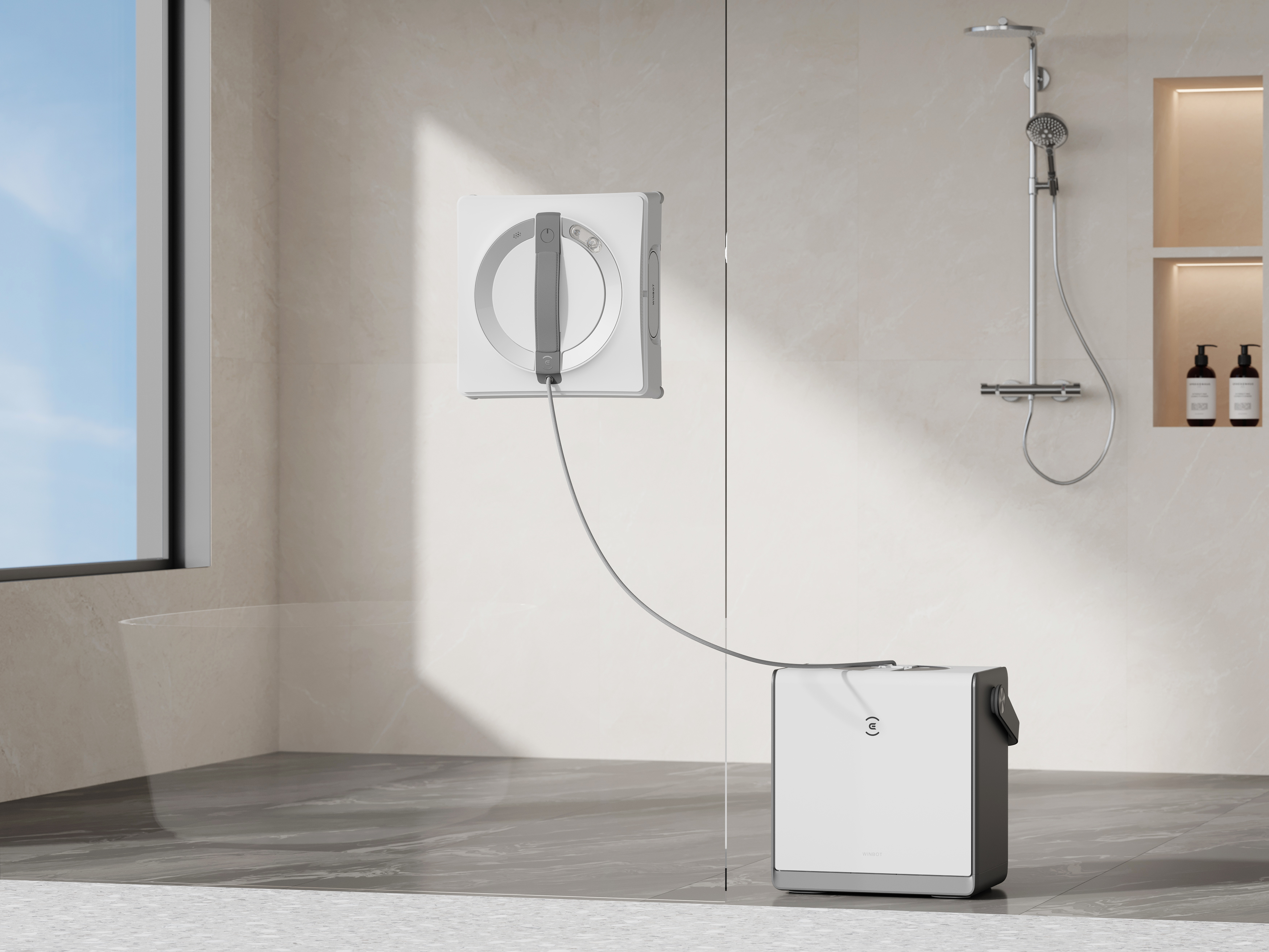 Biały robot do mycia okien przylega do ściany prysznicowej, podłączony do stacji bazowej.