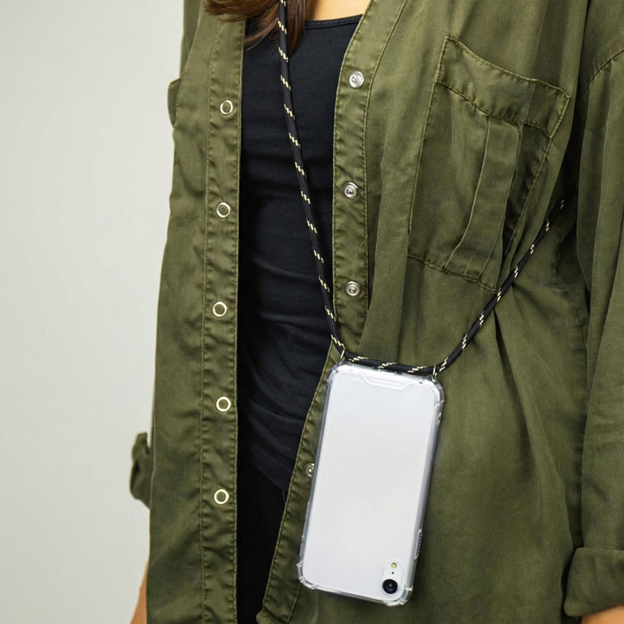 Personne portant un téléphone avec cordon sur la poitrine, veste verte.