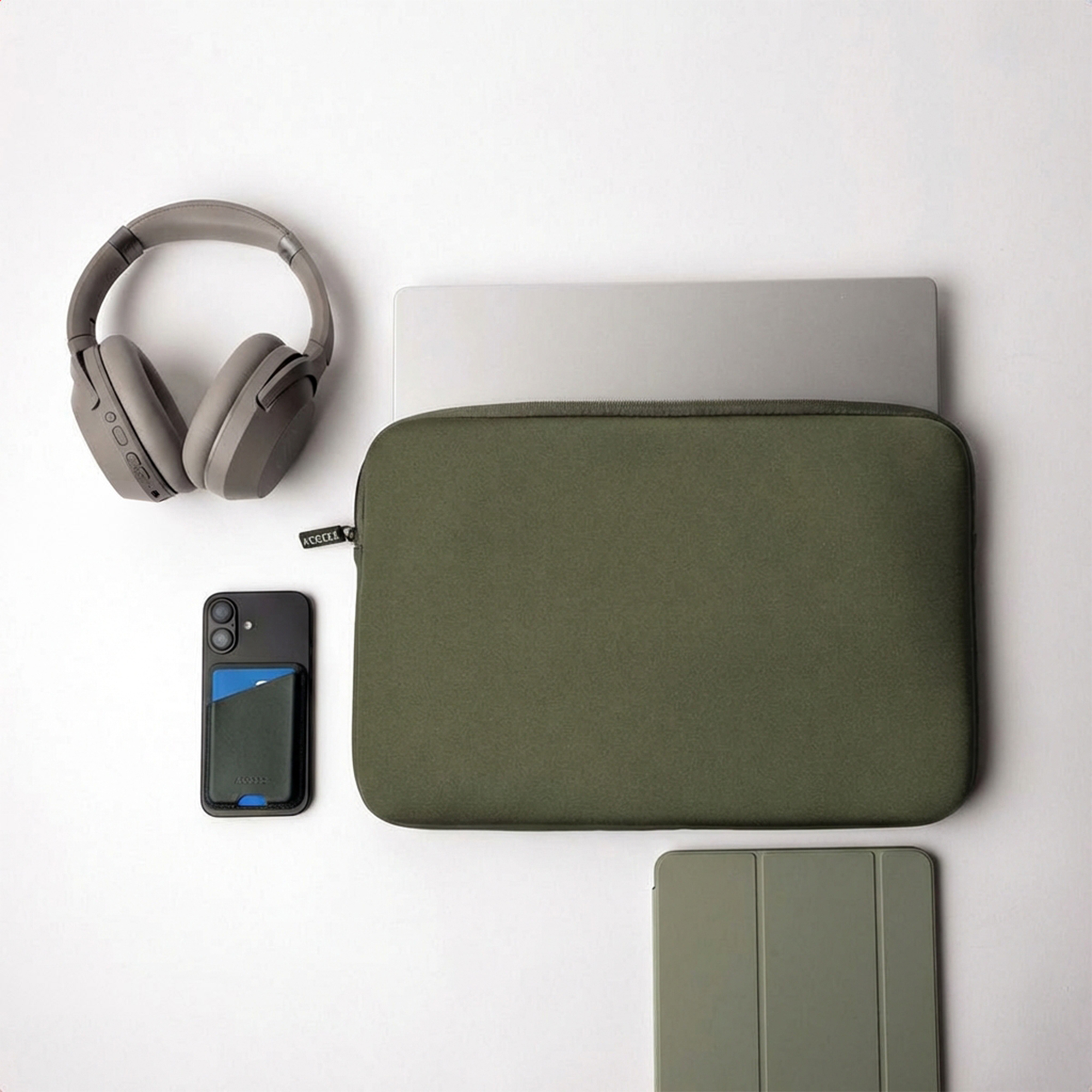 Gray headphones, a smartphone with card holder, a laptop in a green sleeve.