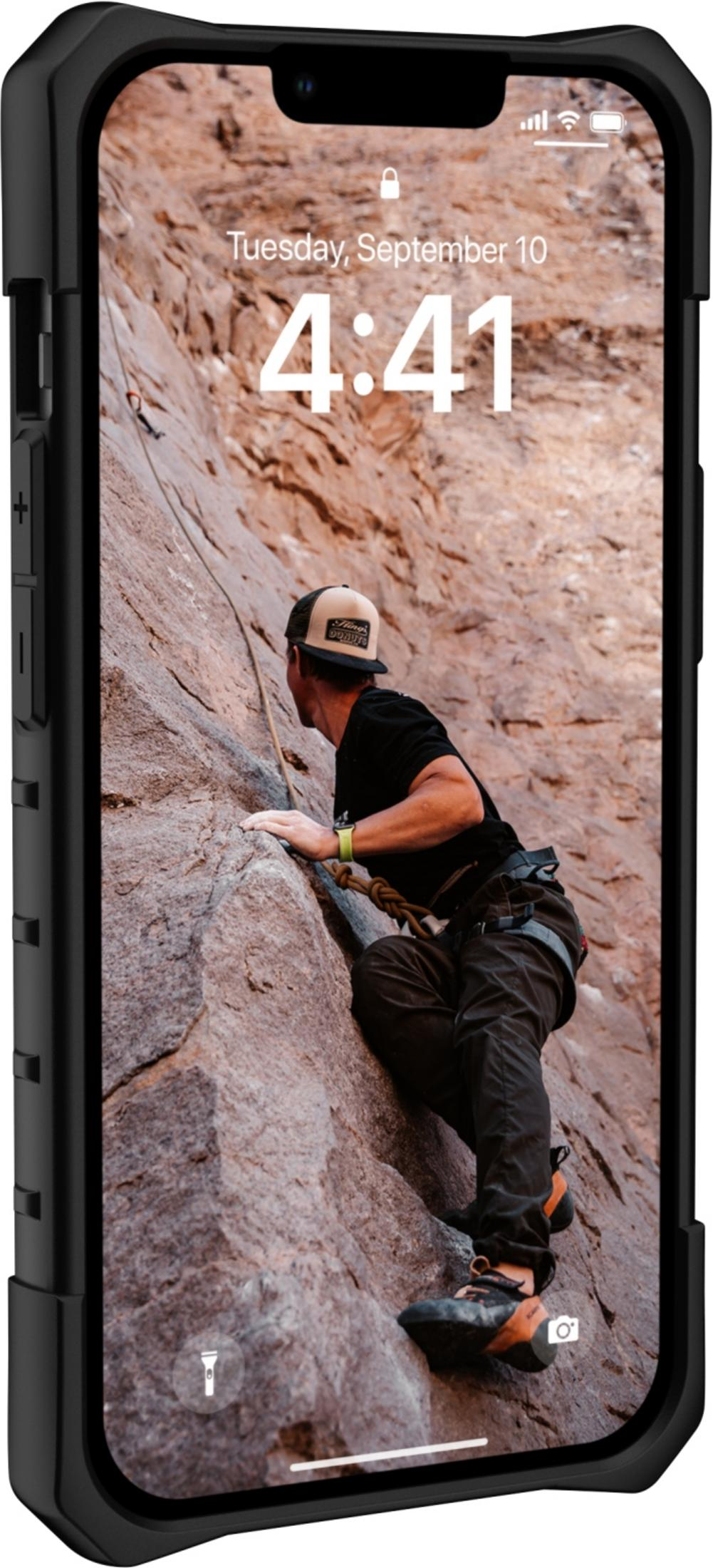 Ein Mann klettert einen Felsen hoch, gesichert durch ein Seil.