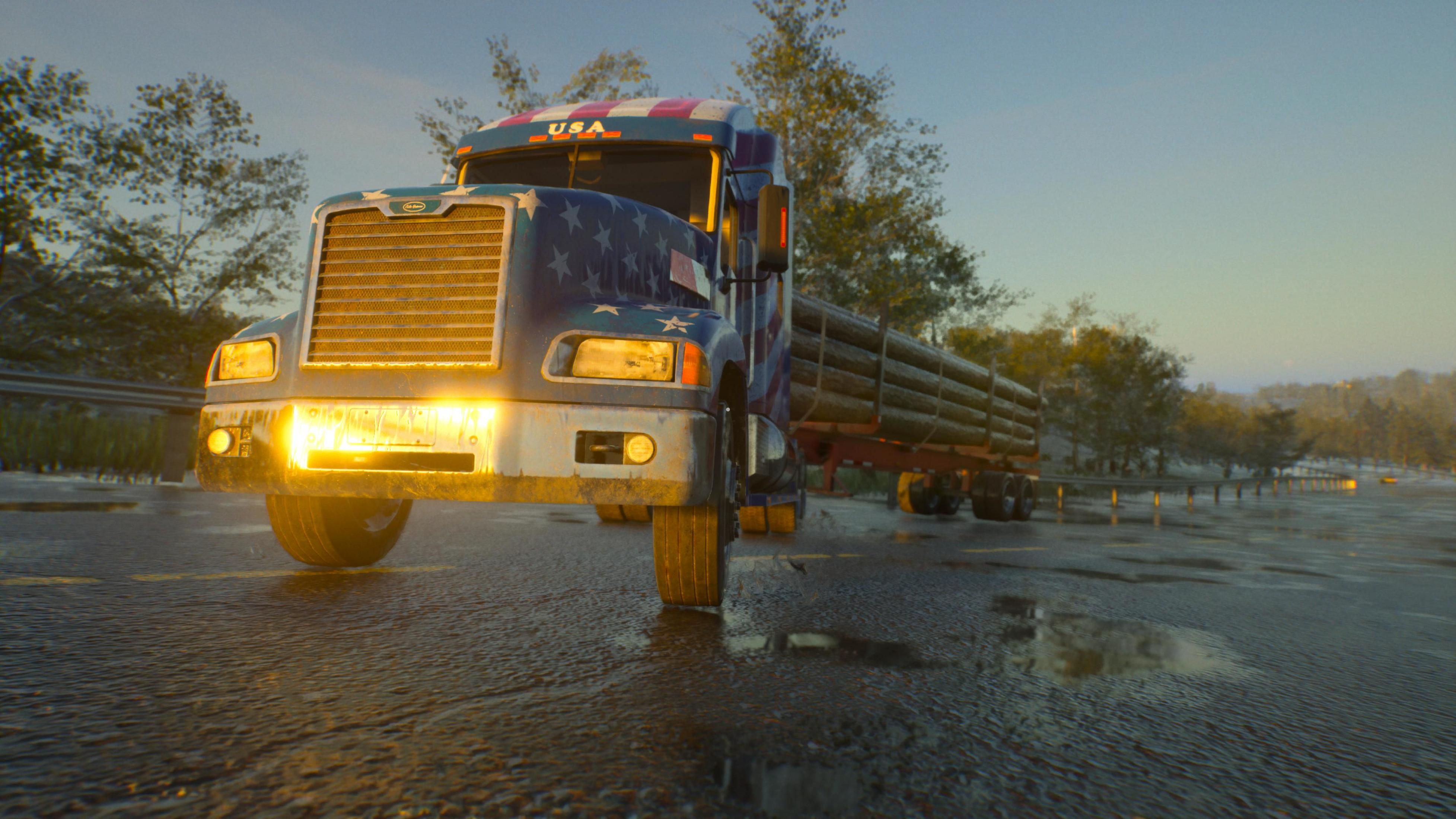 Ein LKW mit Sternenmuster fährt auf nasser Straße bei Sonnenuntergang.