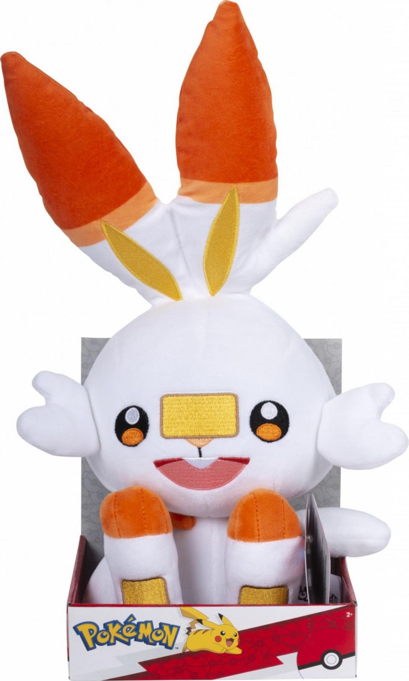 Ein weißer Pokémon-Plüsch mit orangefarbenen Ohren und Füßen in einer Box.