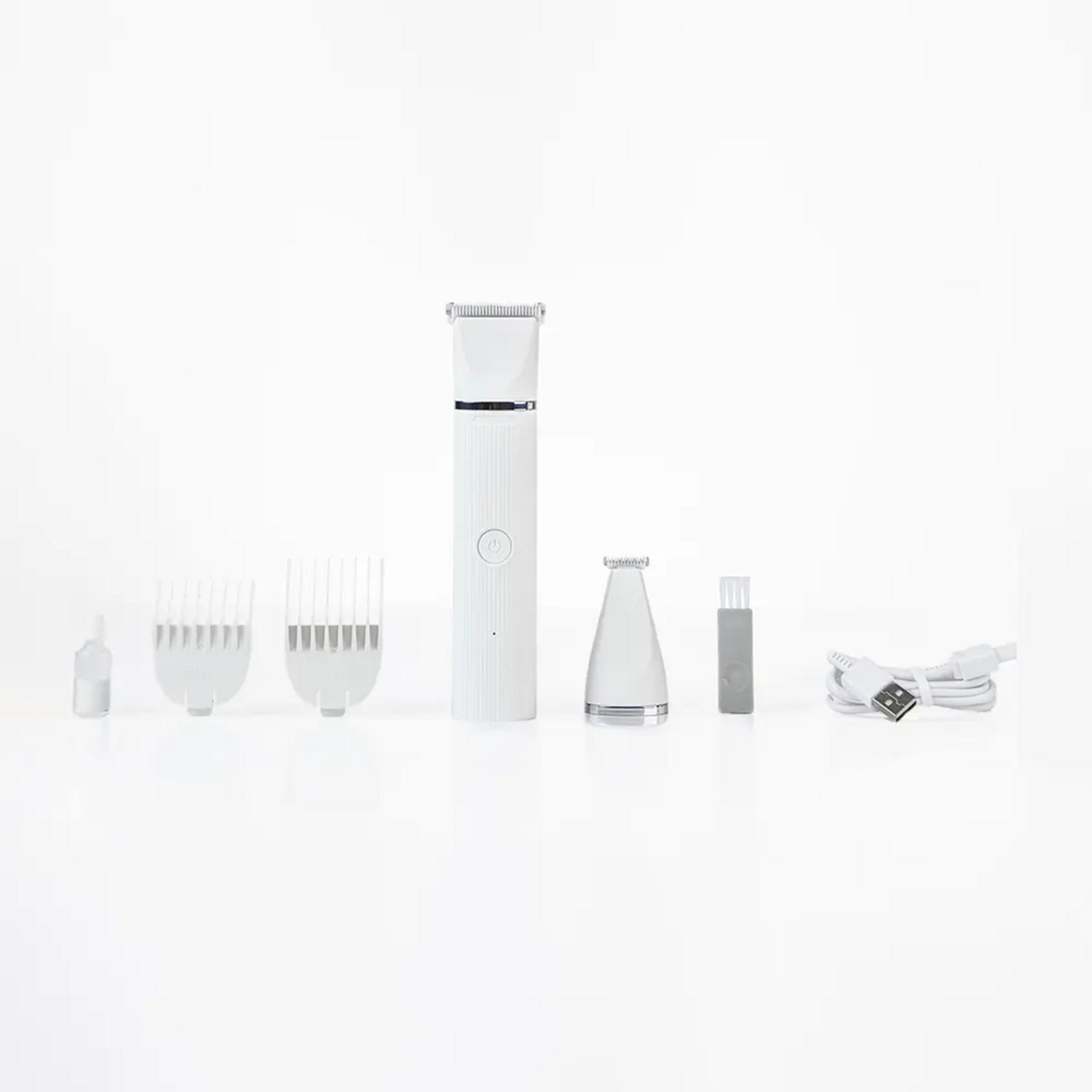 Biała maszynka do strzyżenia włosów z akcesoriami: grzebienie, szczoteczka, fiolka, kabel ładujący.