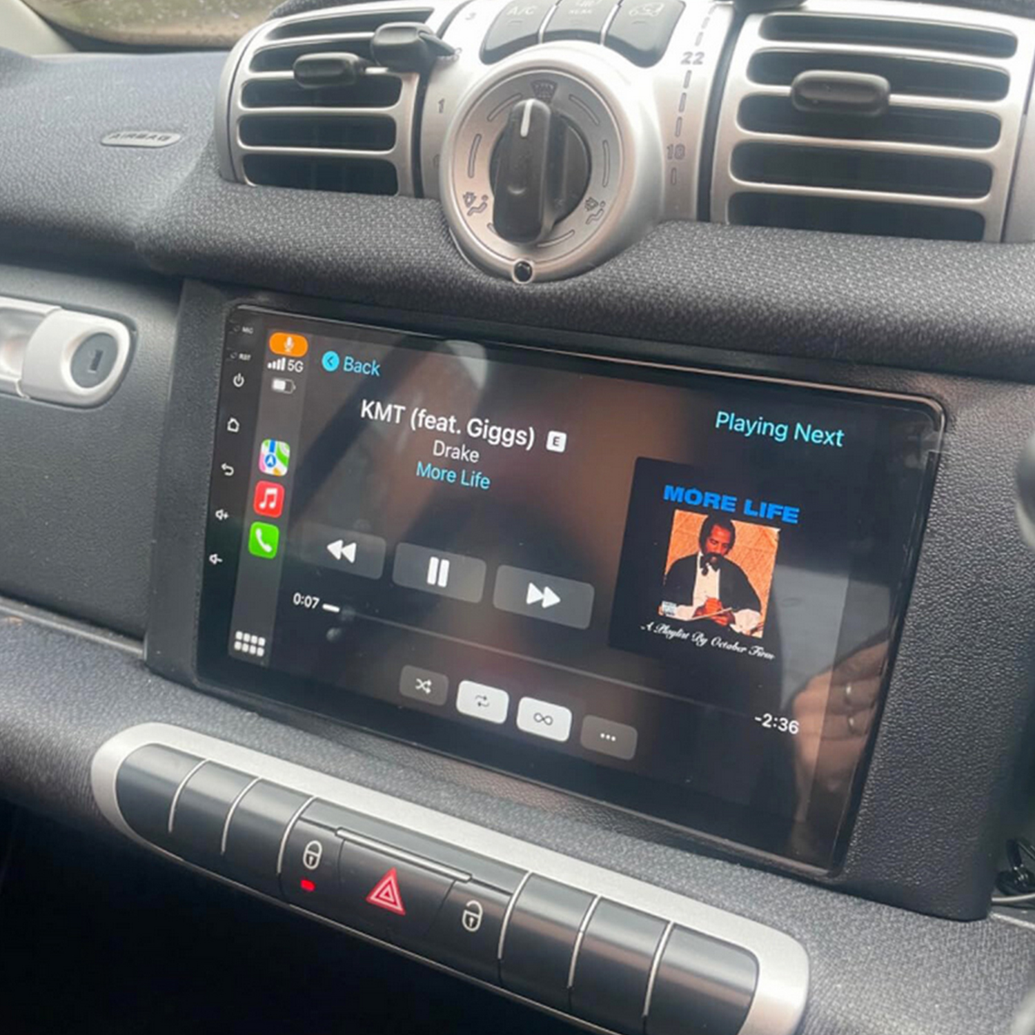 Lo schermo di un autoradio mostra la copertina dell'album 'More Life' e i dettagli del brano.