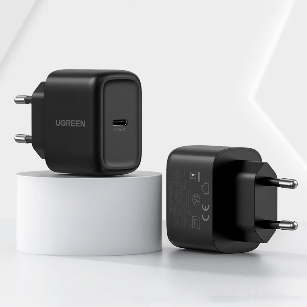 Dwa czarne ładowarki USB-C, jedna z przodu, druga na białym postumencie.
