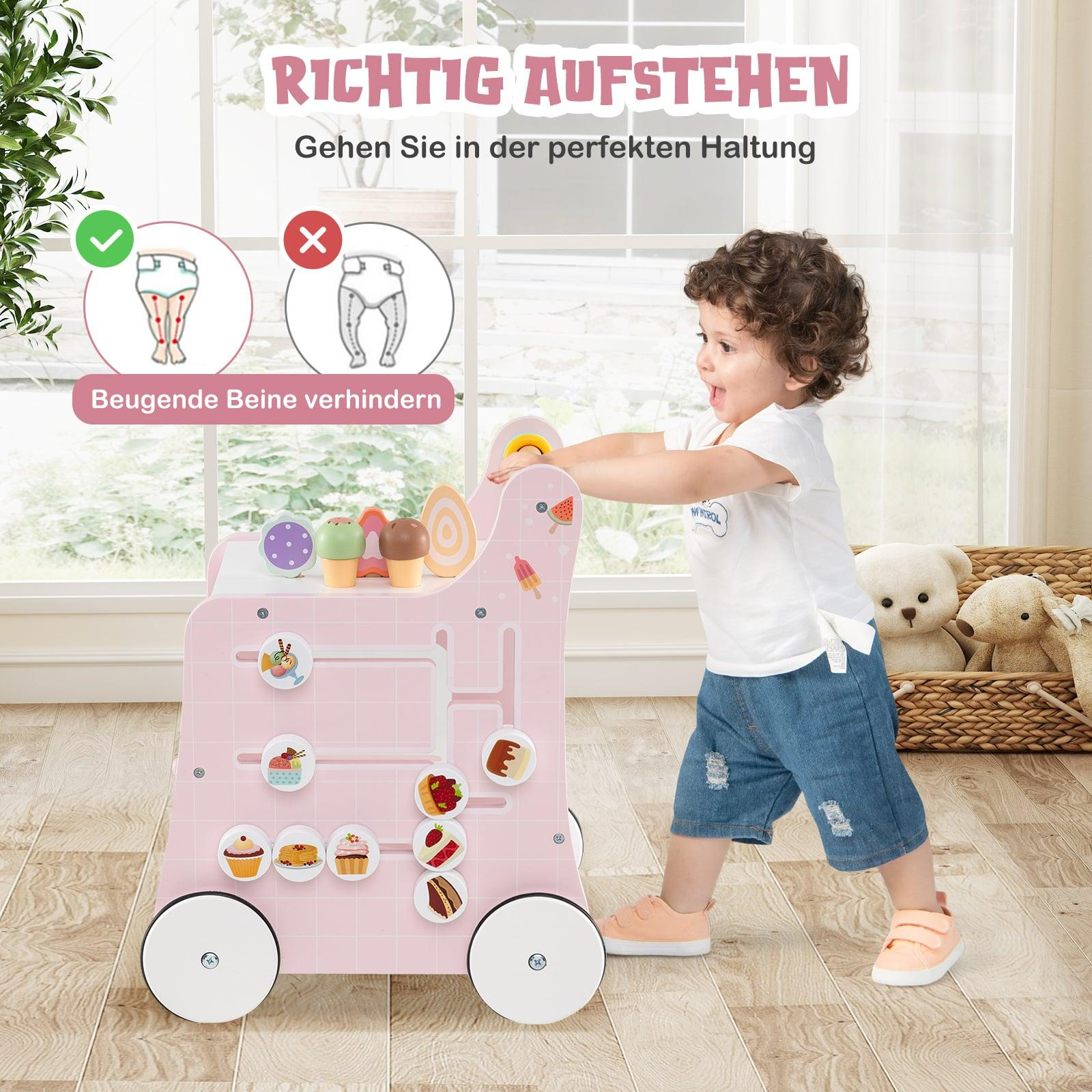 Een peuter duwt een roze speelgoedkar versierd met ijsjes en taartjes.