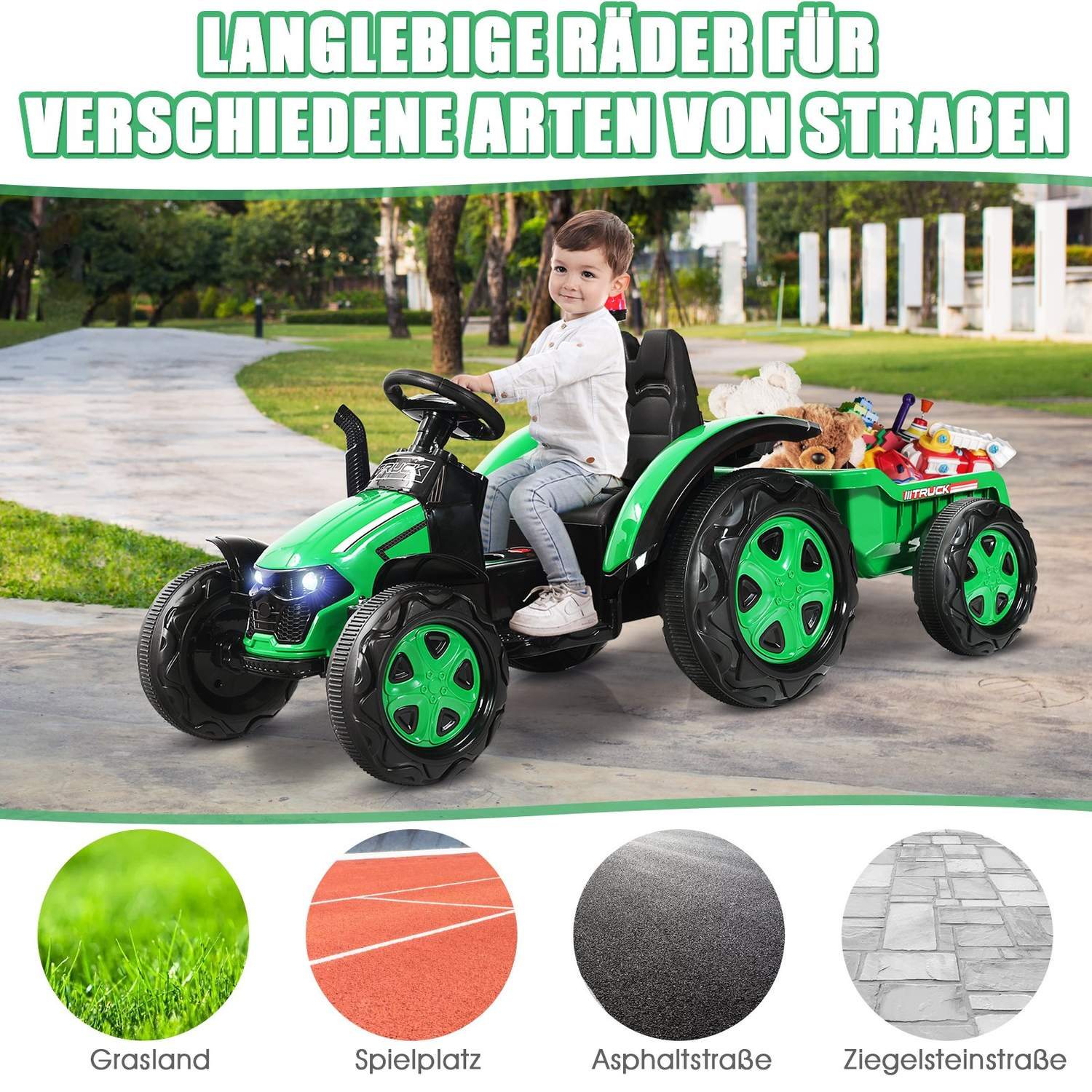 A boy rides a green toy tractor with a trailer loaded with toys.