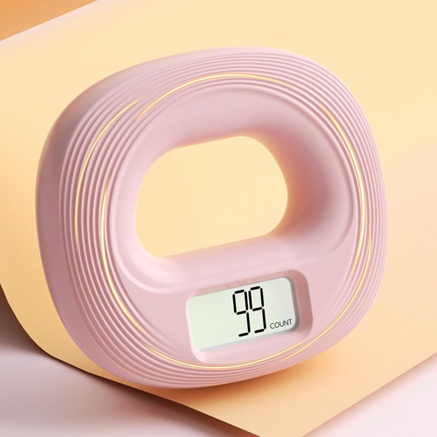 Ein pinker Handtrainer mit Ringform und digitaler Anzeige, die 99 zählt.