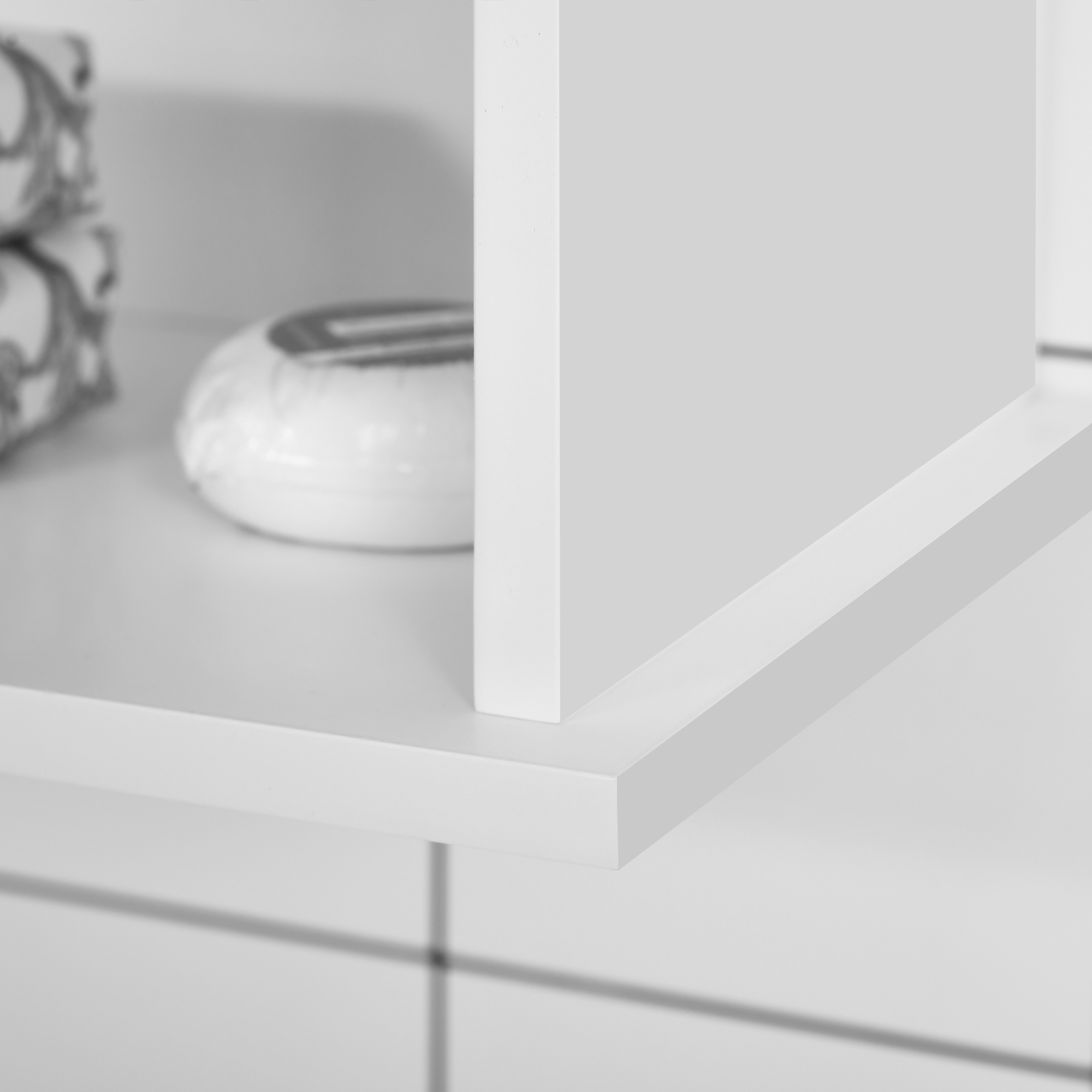 Estantería blanca con decoraciones y sombras.