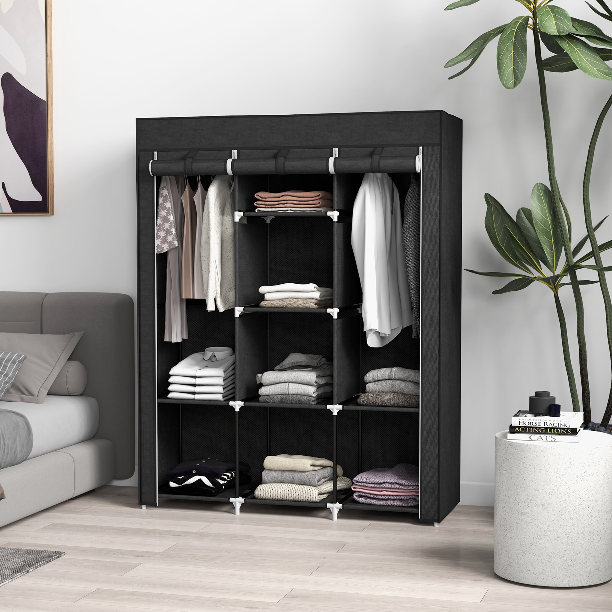 Armario de tela negro con ropa y textiles doblados, junto a una cama.