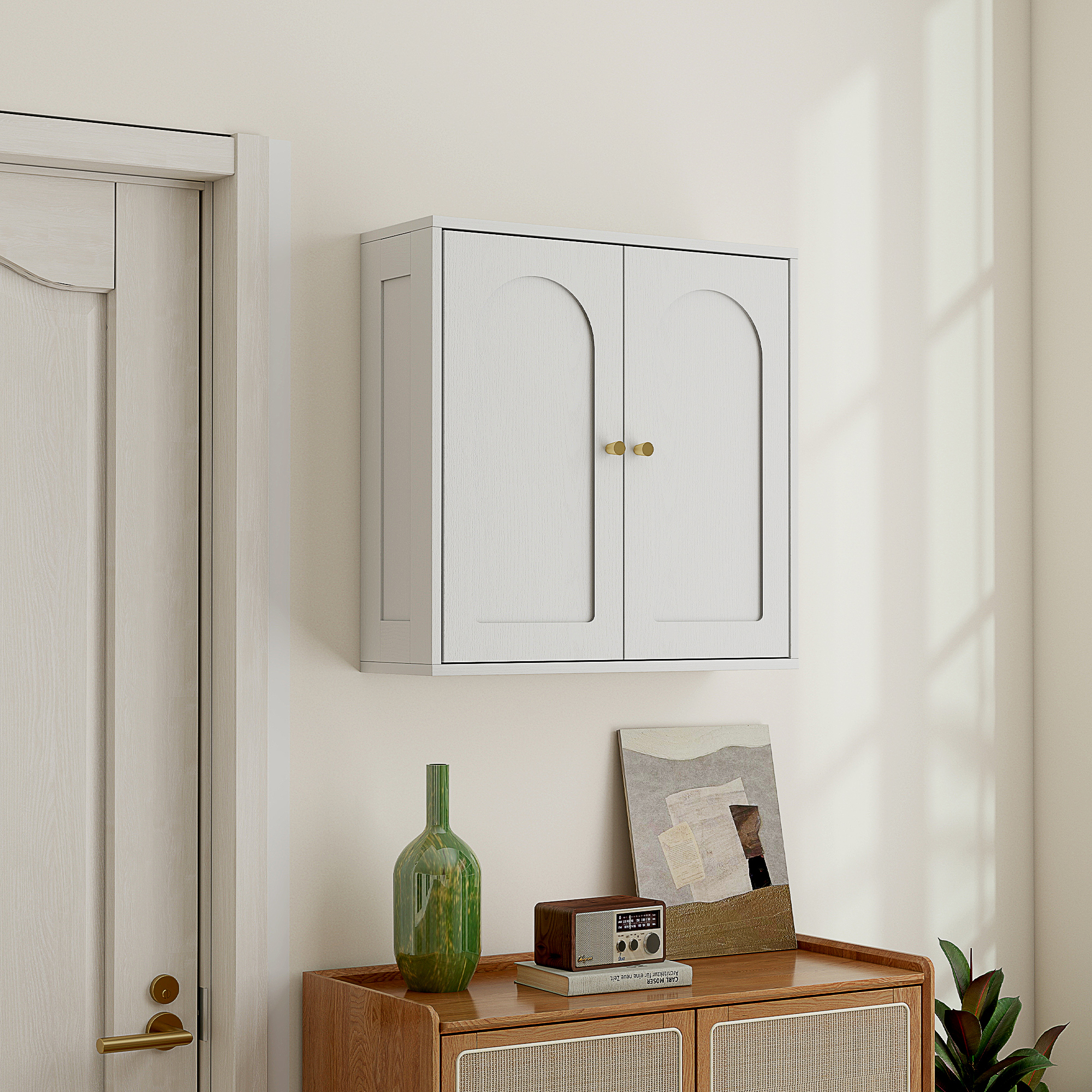 Un armario blanco de pared con dos puertas y pomos dorados.