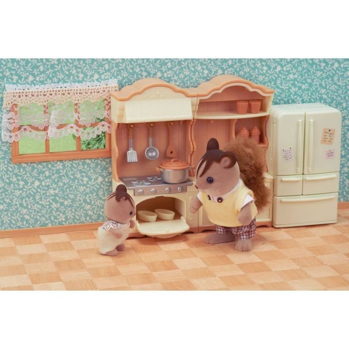 Dos juguetes de ardilla en una cocina. Un juguete grande junto a la estufa y el refrigerador. Un juguete pequeño cerca de la estufa.